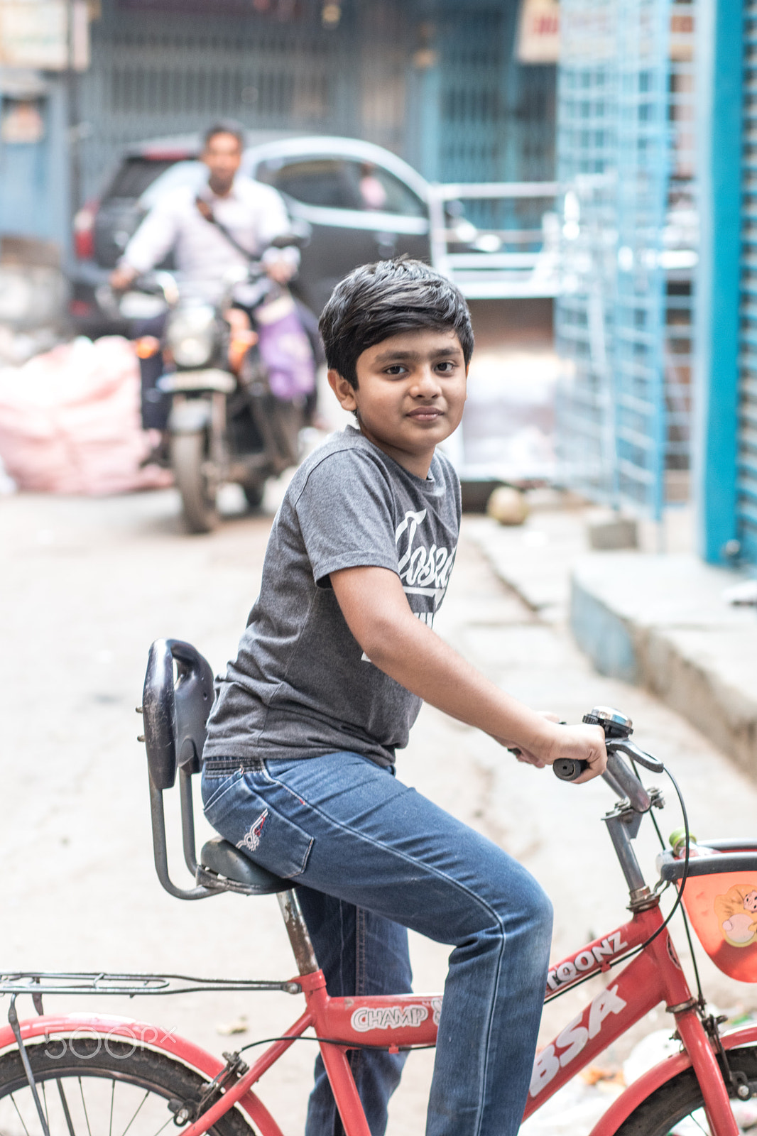 Canon EOS 80D + Canon EF 85mm F1.8 USM sample photo. On a street young boy with a bicycle photography