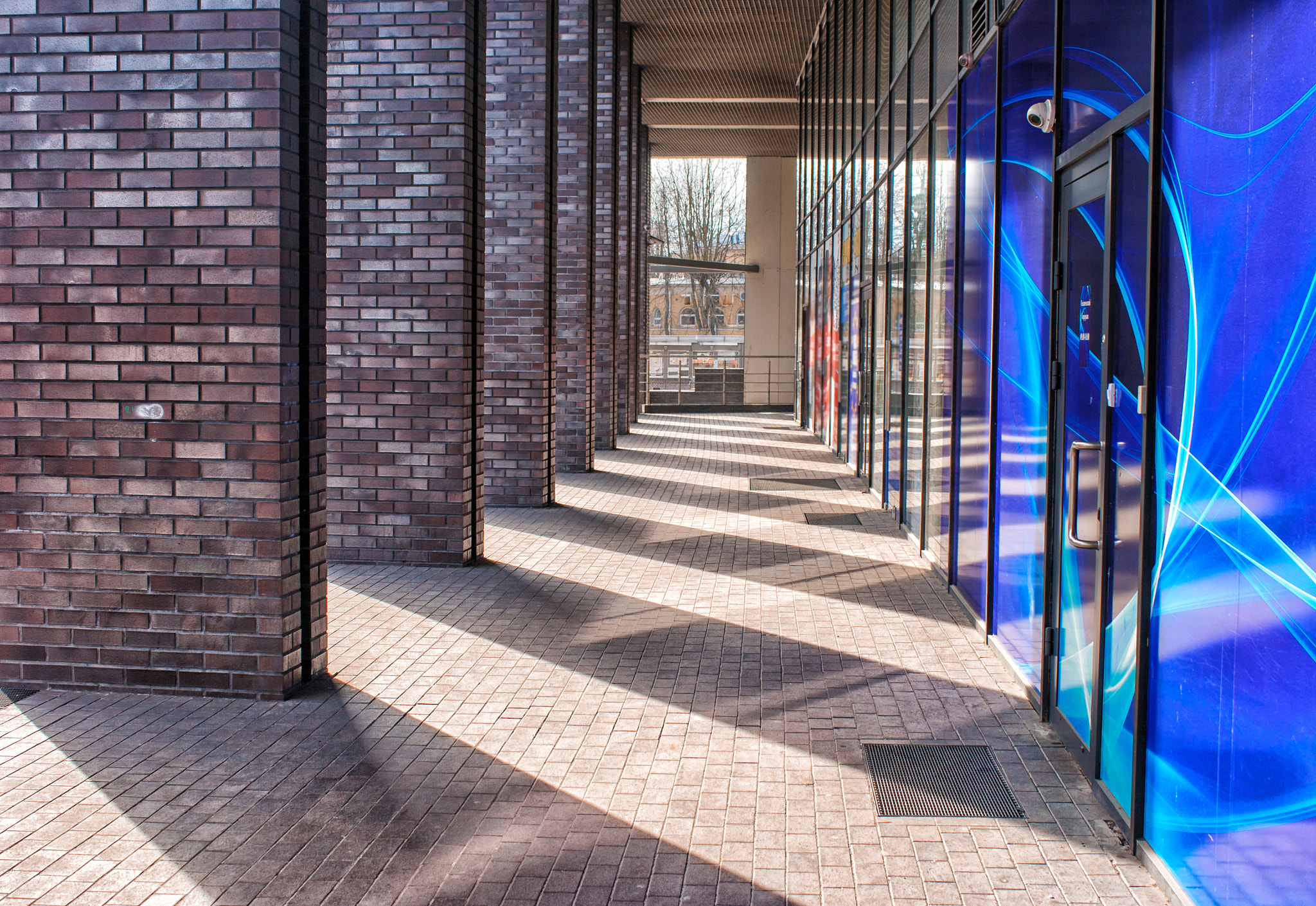 Canon EF-S 18-55mm F3.5-5.6 IS sample photo. Corridor of columns in a modern building photography