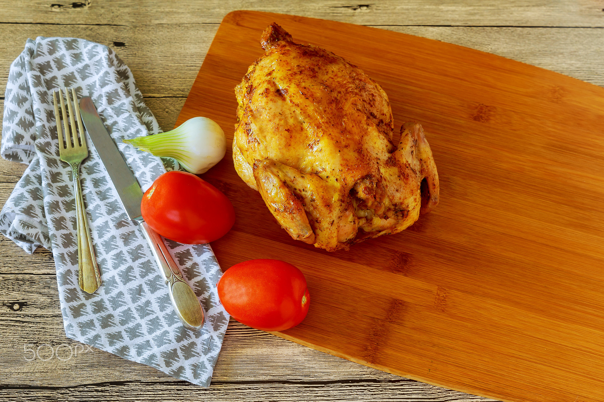 Roasted chicken and vegetables on the wooden table with