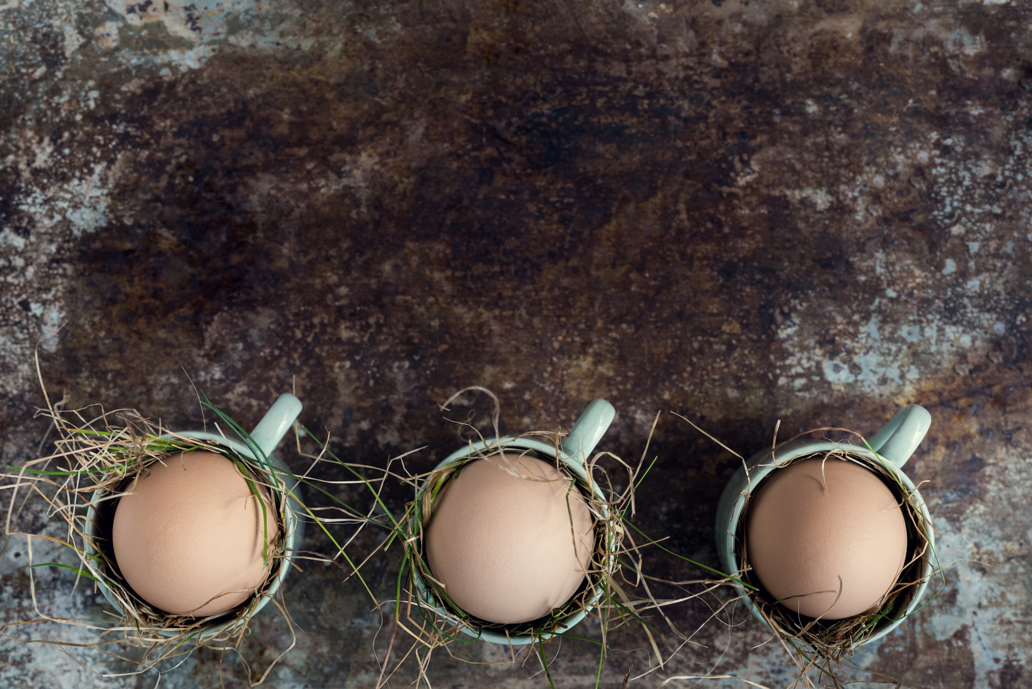 Uncolored natural easter eggs in green espresso cups, happy easter concept, retro easter background