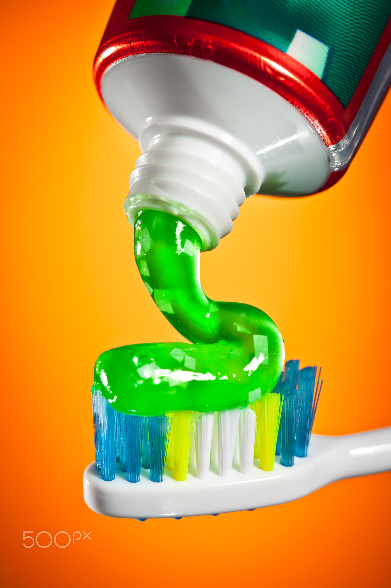 toothpaste being squeezed onto a toothbrush