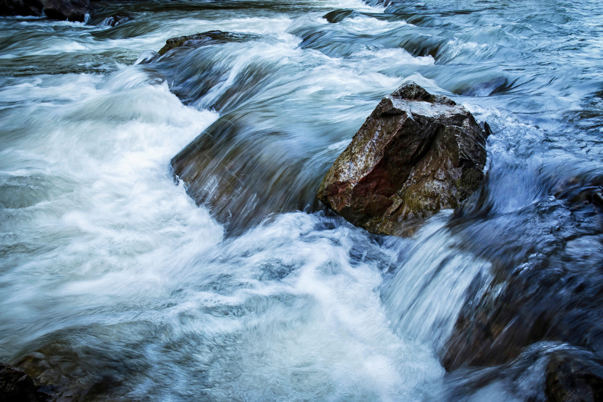 Nikon D5500 + Nikon AF-S DX Nikkor 16-85mm F3.5-5.6G ED VR sample photo. Detail of a river with a stone in the foreground photography