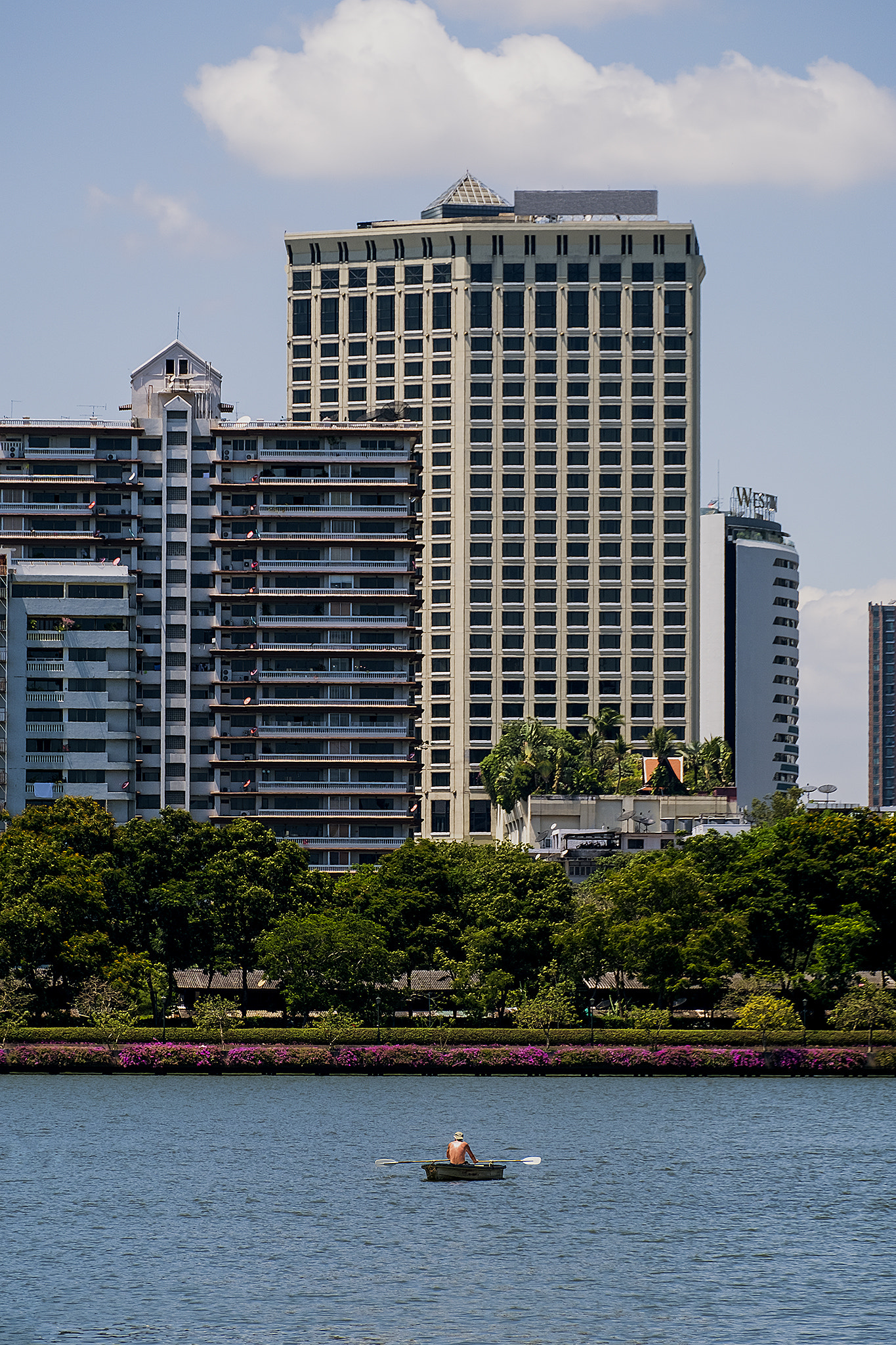 Fujifilm X-T20 sample photo. Man in a black kayak against the background of the city, in bang photography