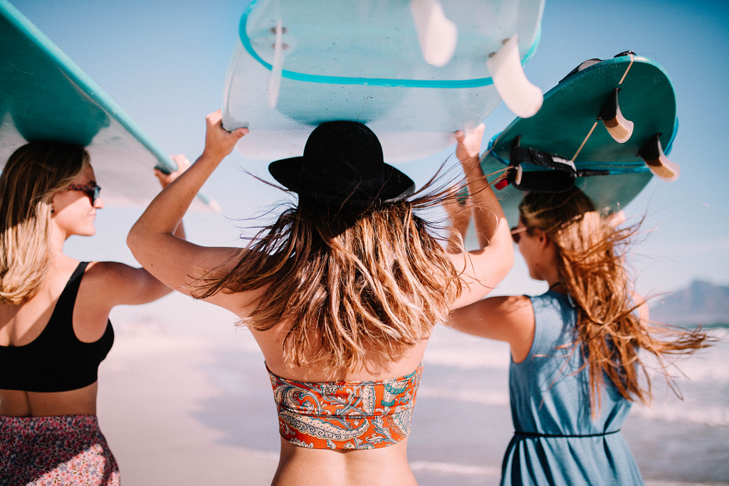 Group of women carrying surfboards at beach by Carina König on 500px.com