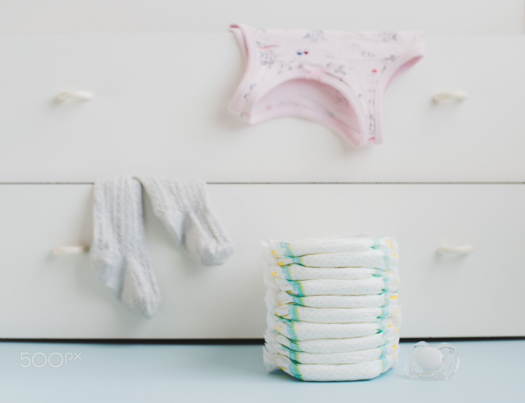 A stack of diapers and a locker with linens