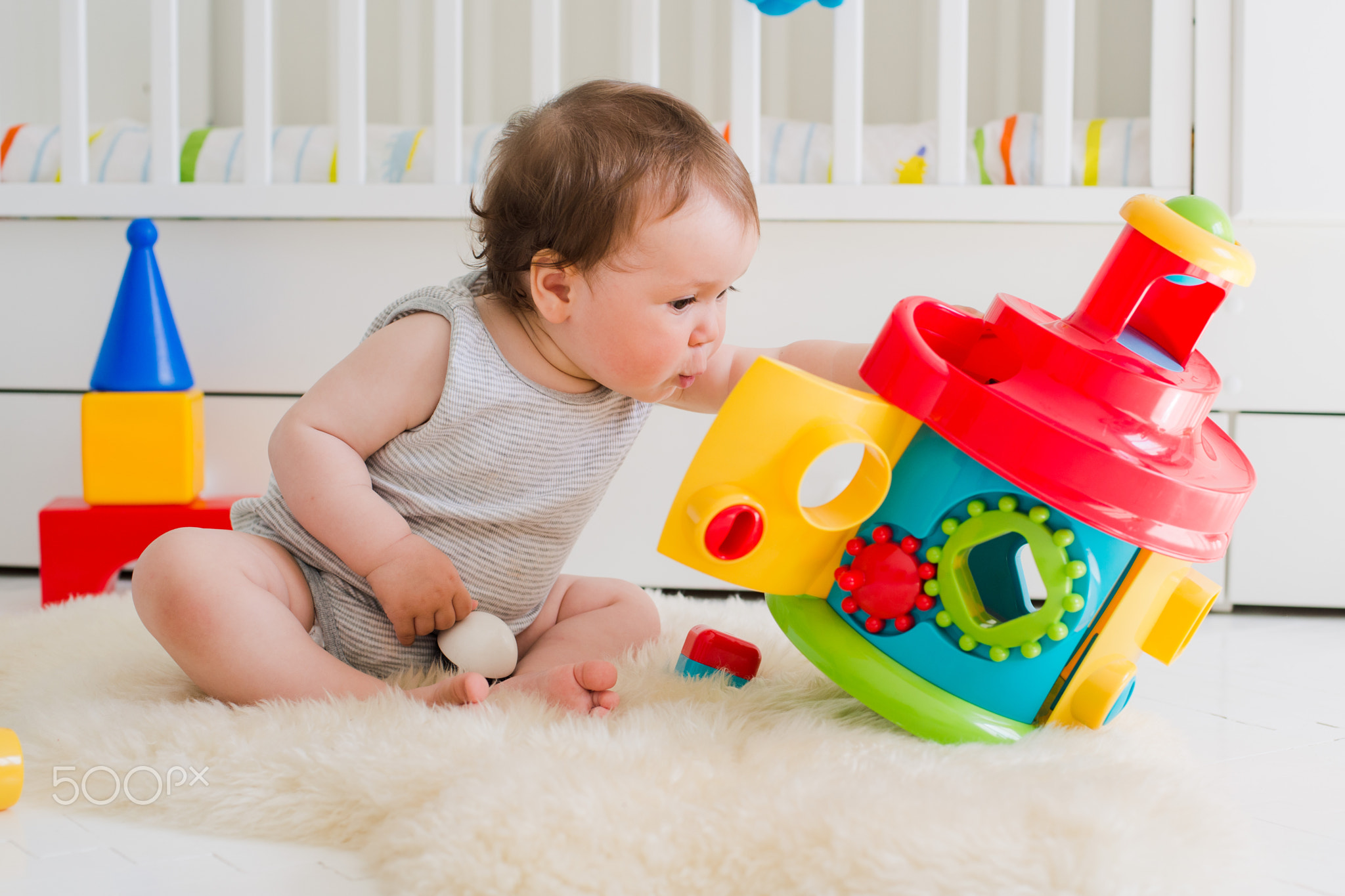 baby playing with educational toys lying