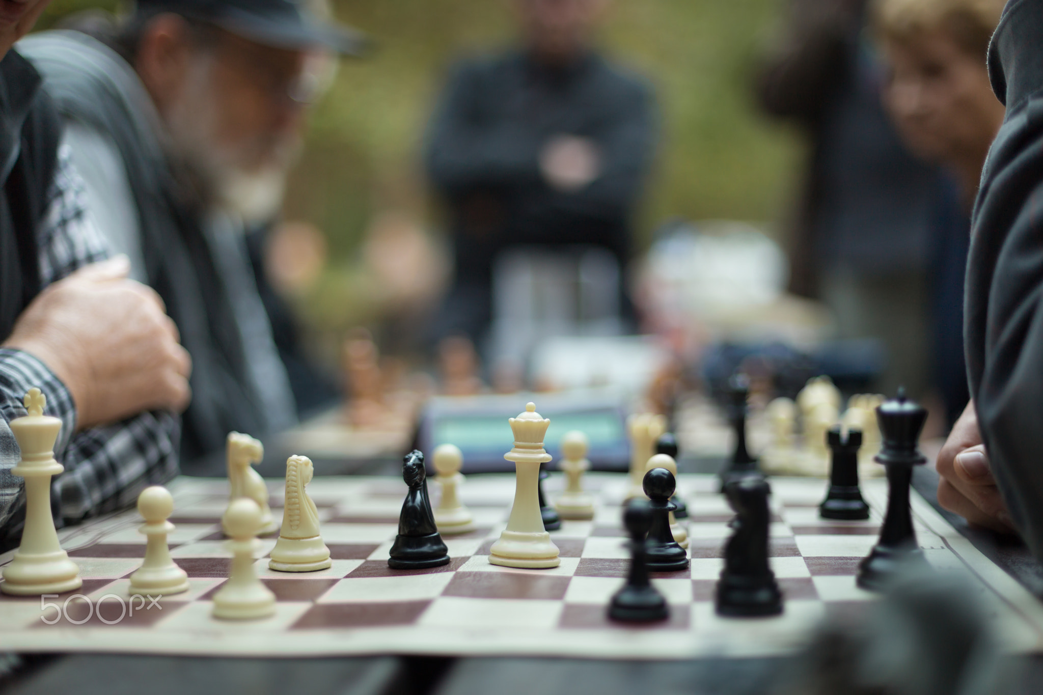 Close up of senior men playing chess.