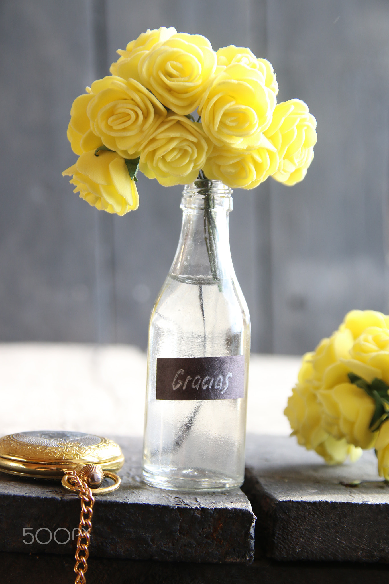 Gracias label and Flowers in a glass bottle.
