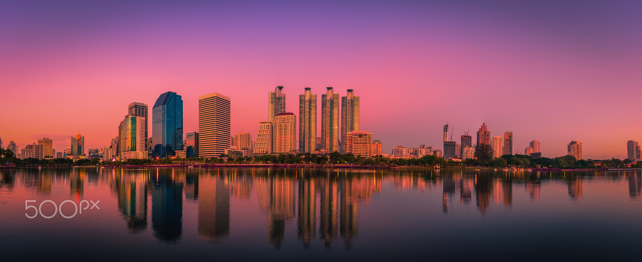 Cityscape image of Benchakitti Park at sunset in Bangkok, Thail