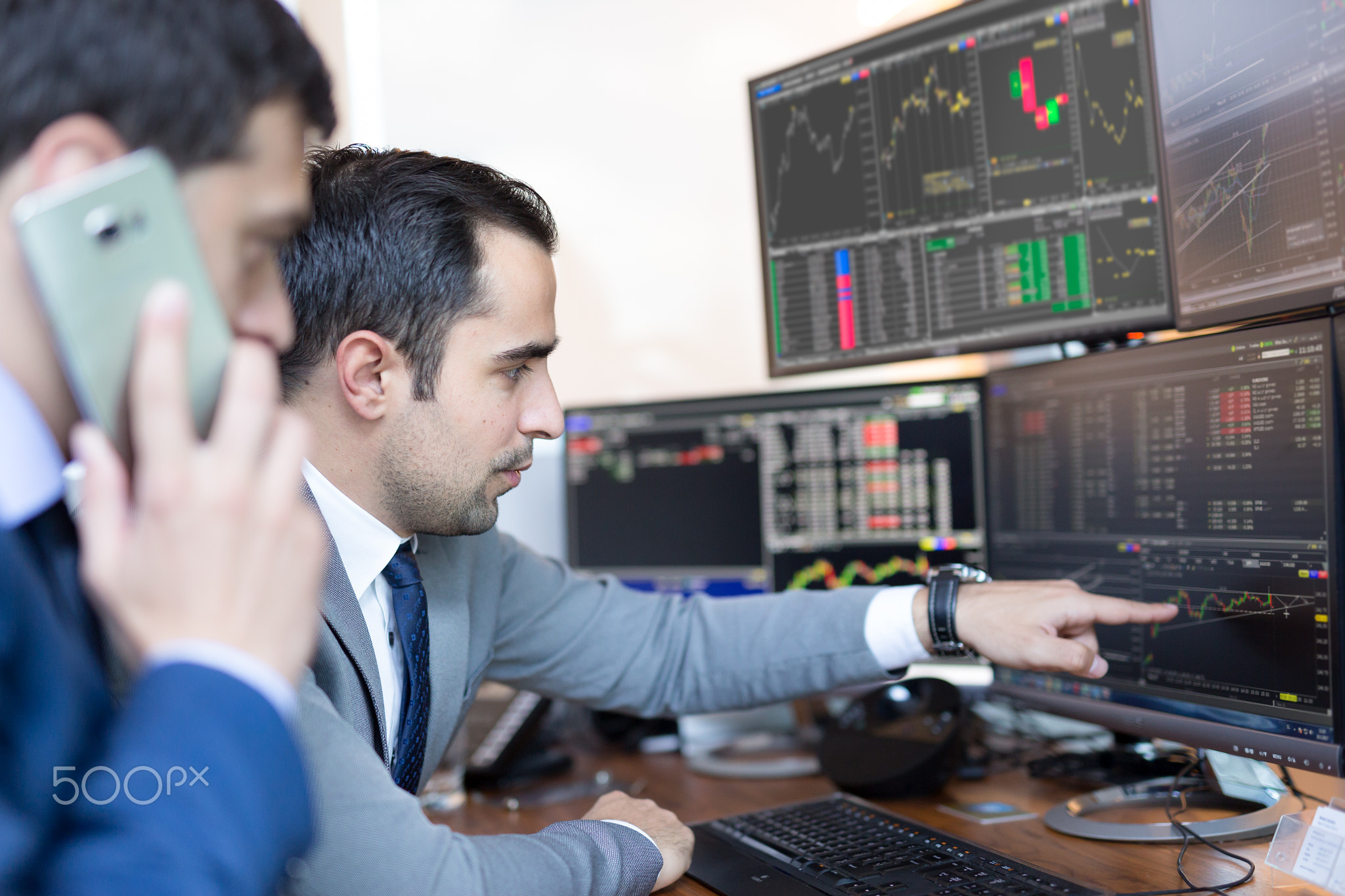 Stock brokers looking at computer screens, trading online.