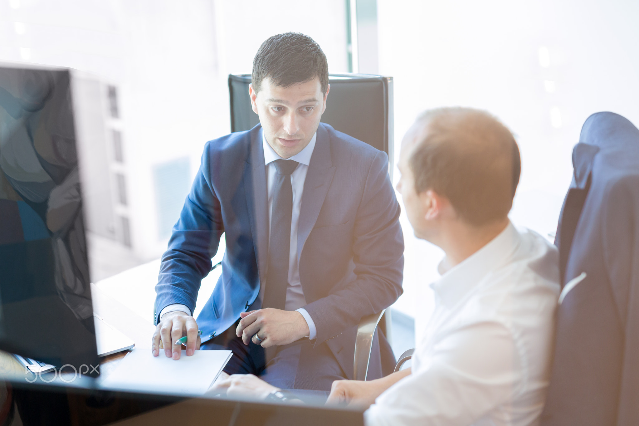 Two businessmen discussing a bisiness problem at meeting in trading office.