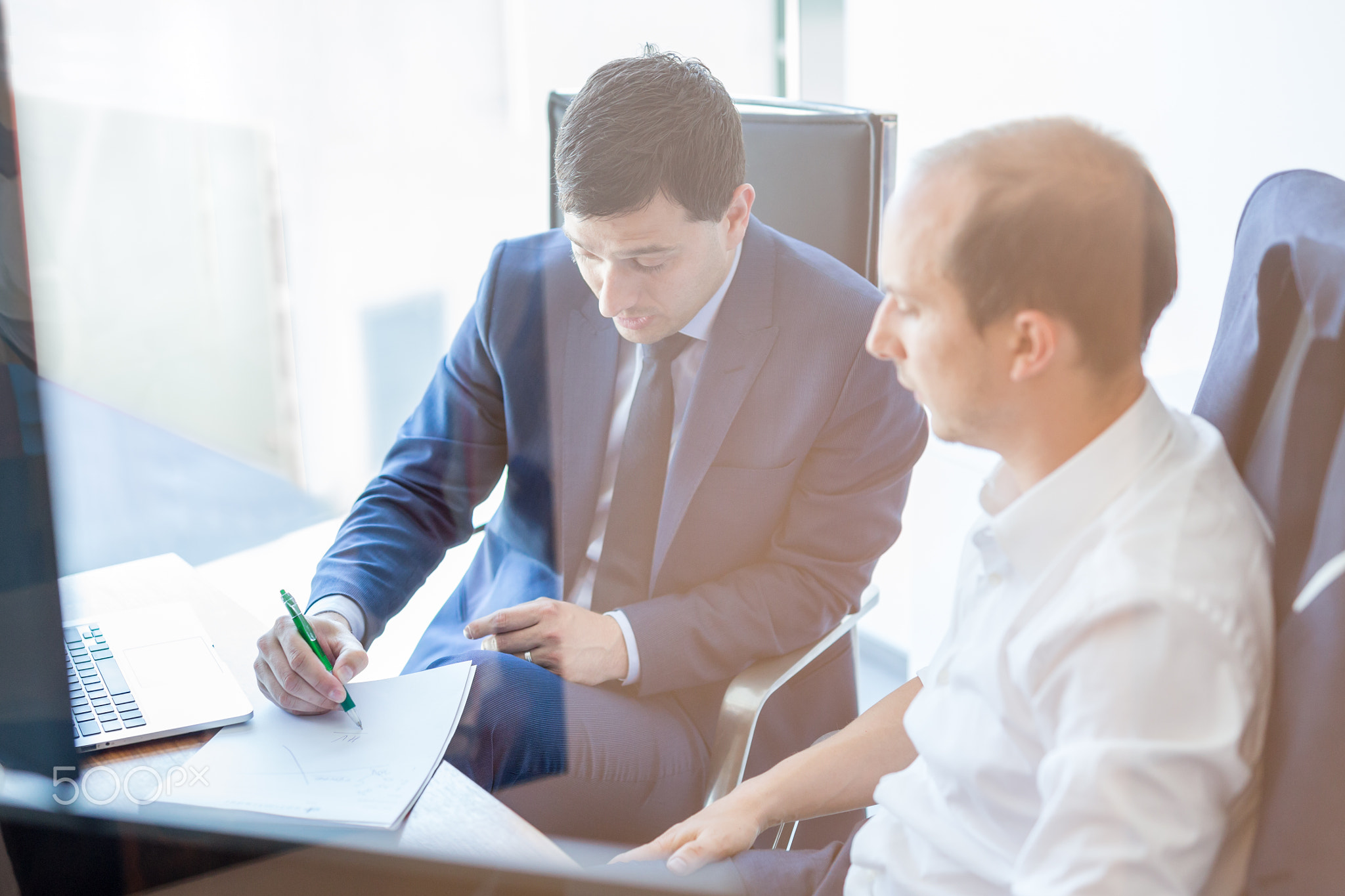 Two businessmen discussing a bisiness problem at meeting in trading office.