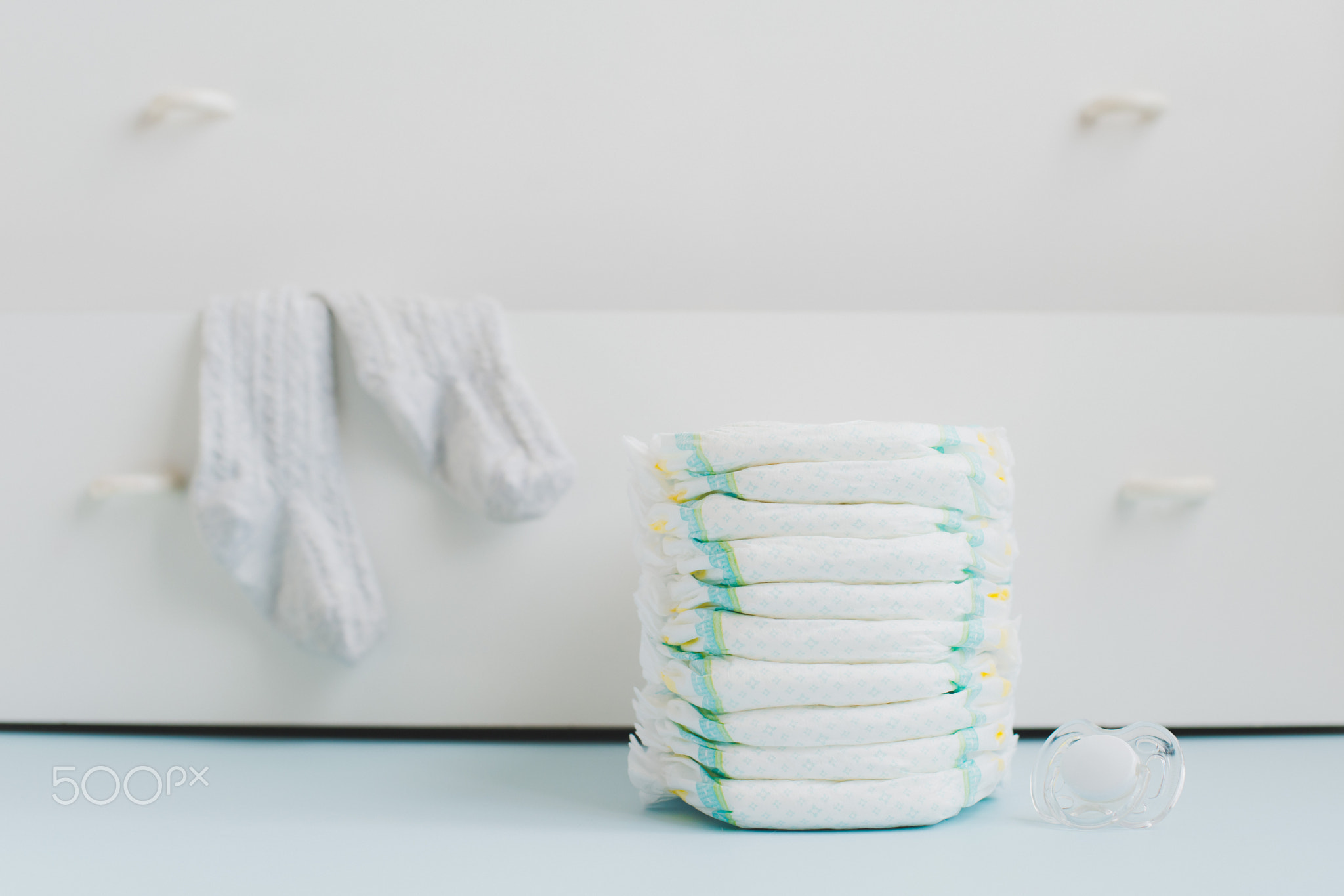 A stack of diapers and a locker with linens