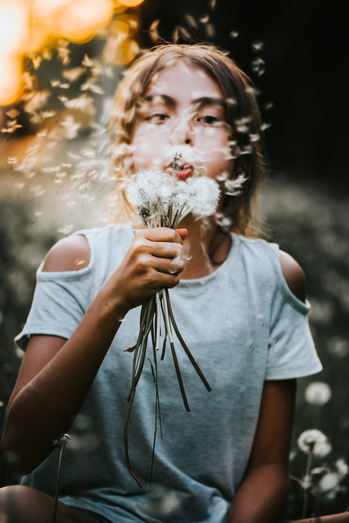 Young girl blowing a dandelion by Gabriela Tulian on 500px.com