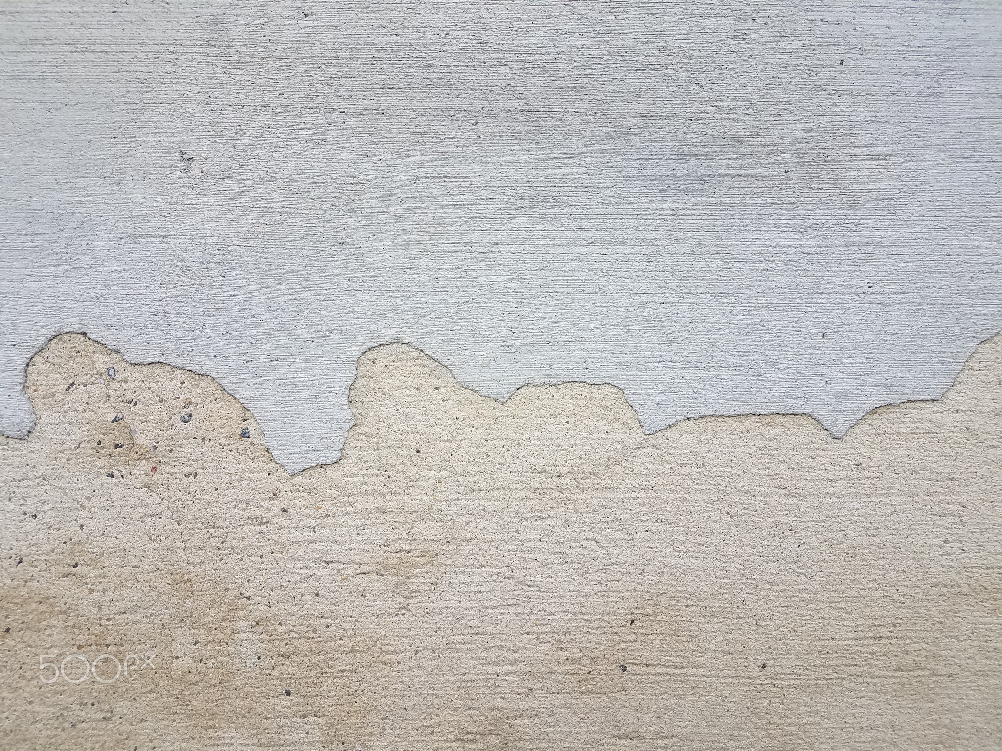 an irregular line dividing white and grey cement