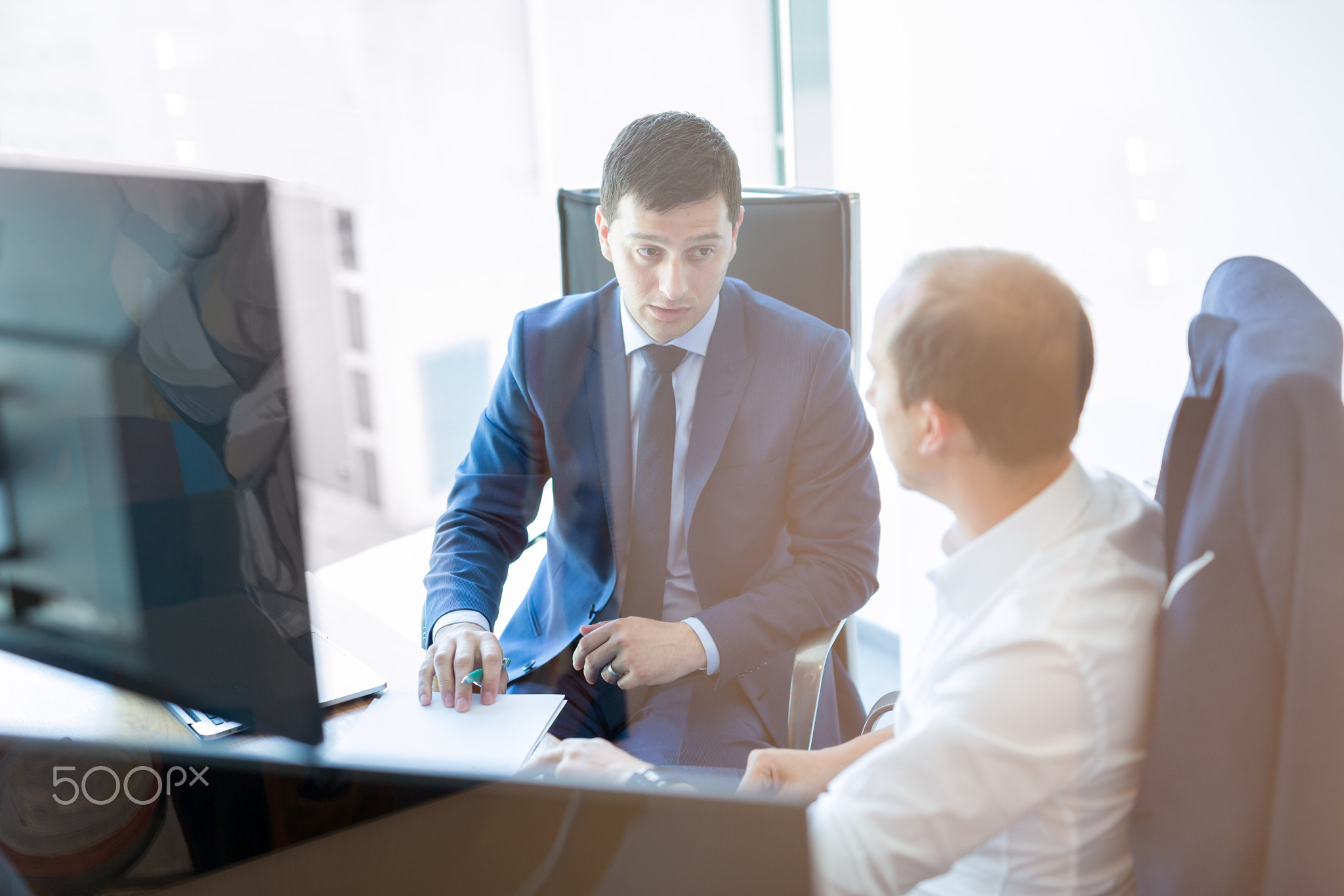 Two businessmen discussing a bisiness problem at meeting in trading office.