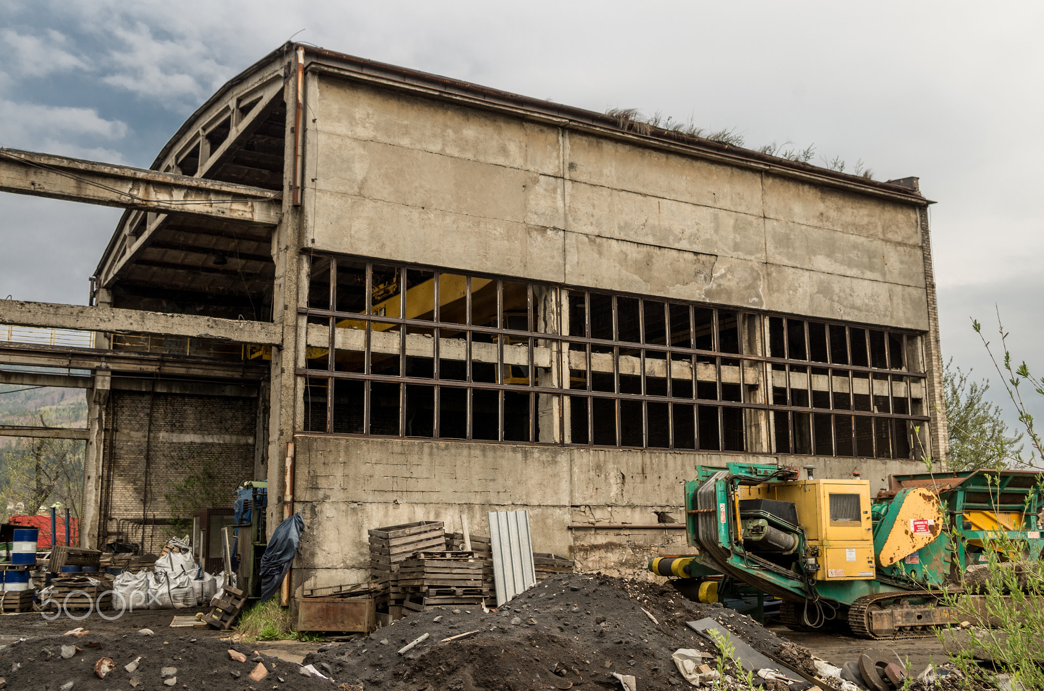 Exterior view of dirty old abandoned vandalised factory ruin, broken window glass rusty steel...