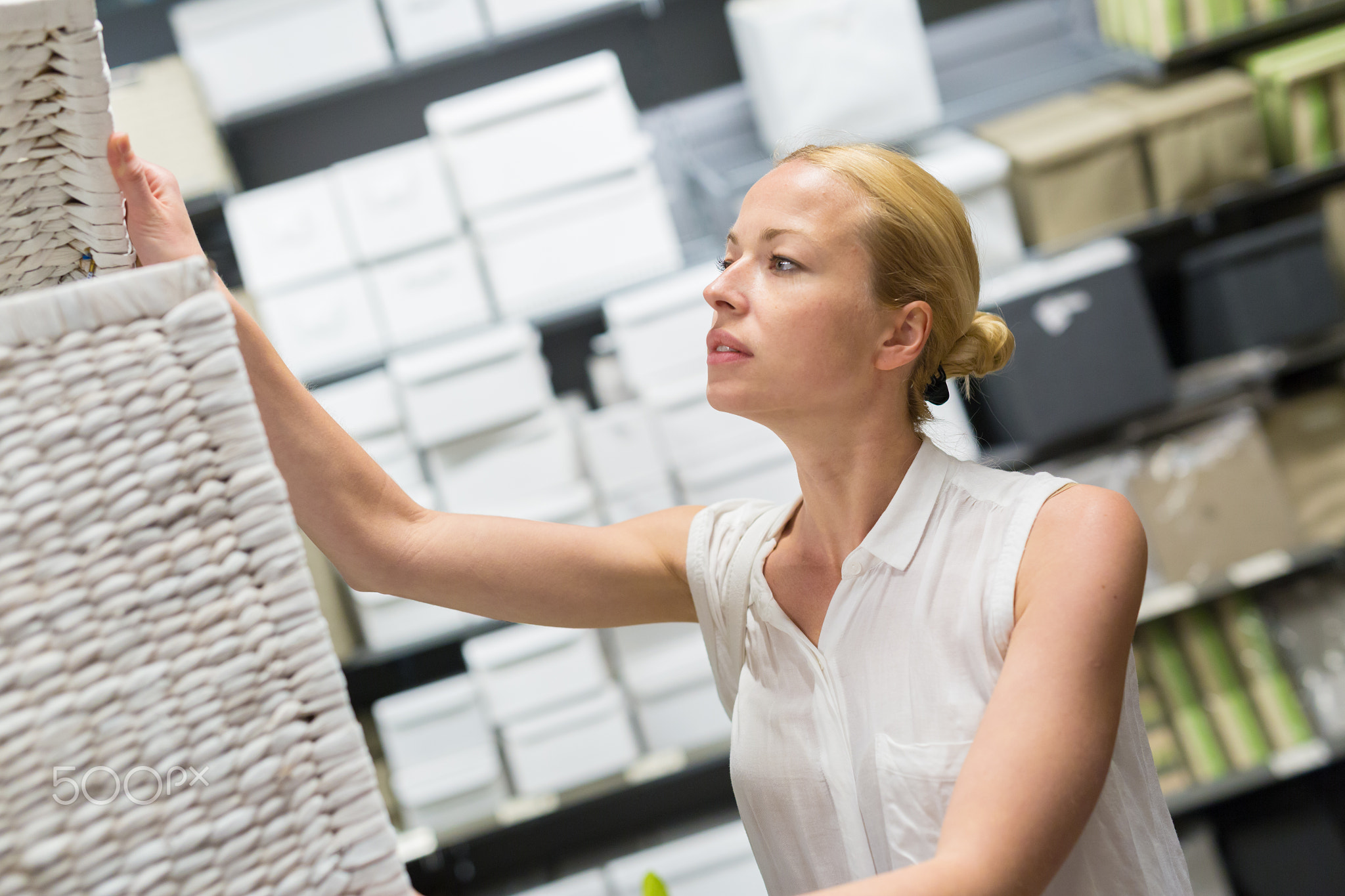 Woman choosing the right item for her apartment in a modern home furnishings store.