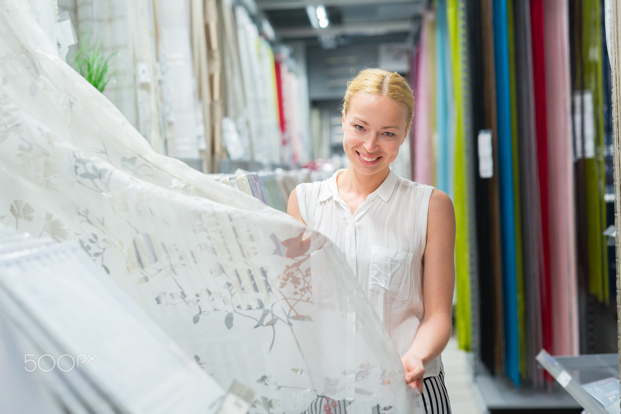 Woman choosing the right item for her apartment in a modern home furnishings store.
