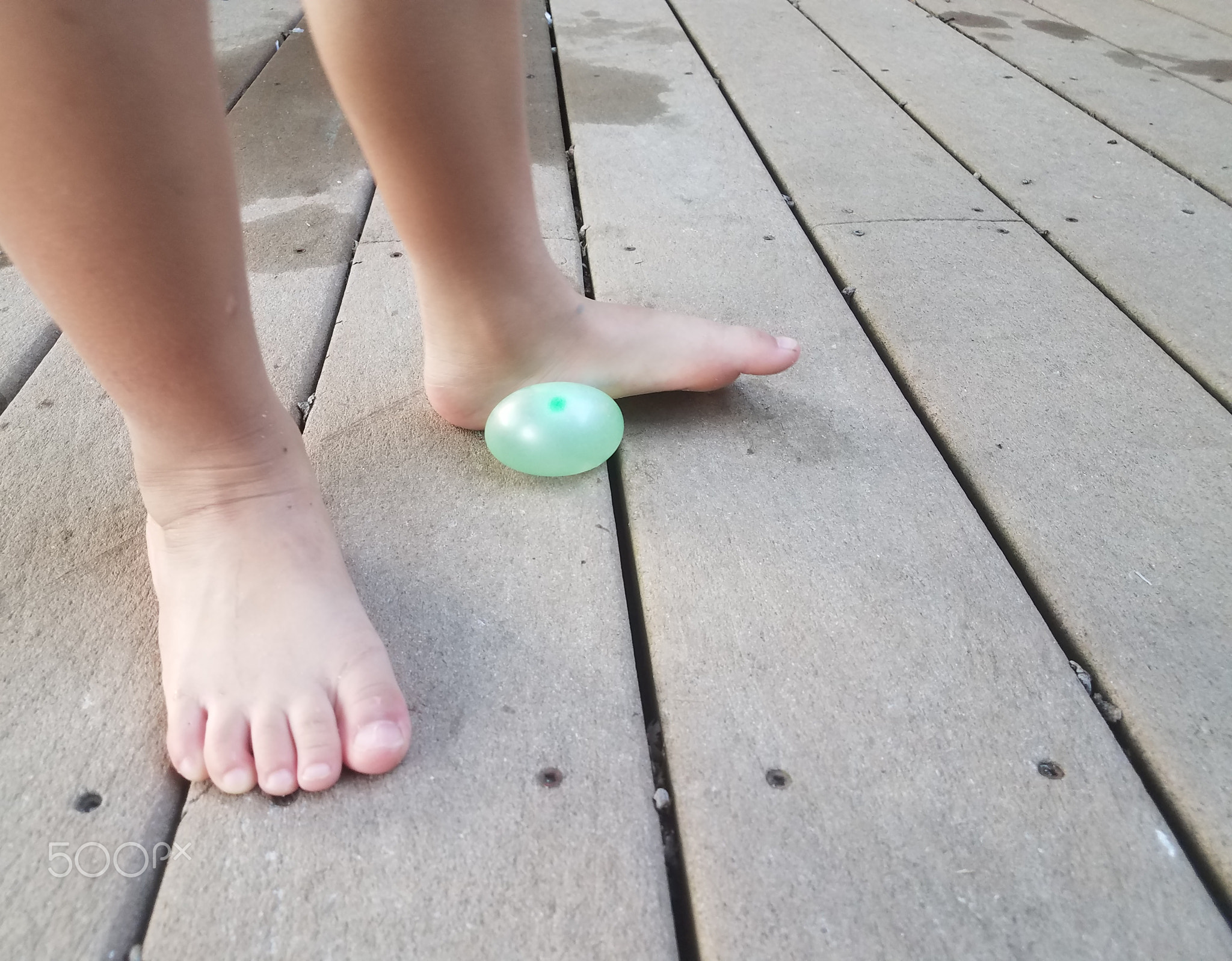 child's foot on water balloon