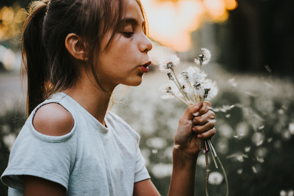 Young girl blowing a dandelion by Gabriela Tulian on 500px.com