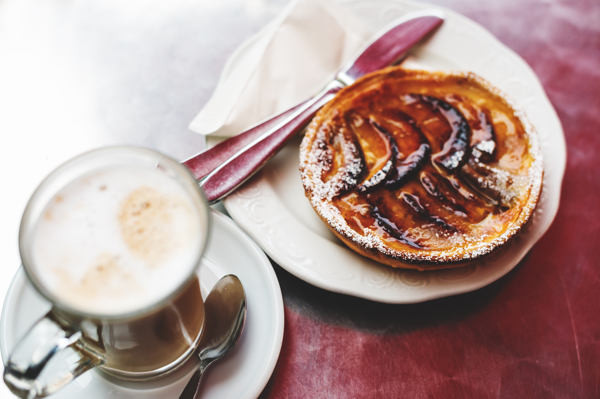 Classic french upside down apple cake Tarte Tatin and latte macchiato, top view