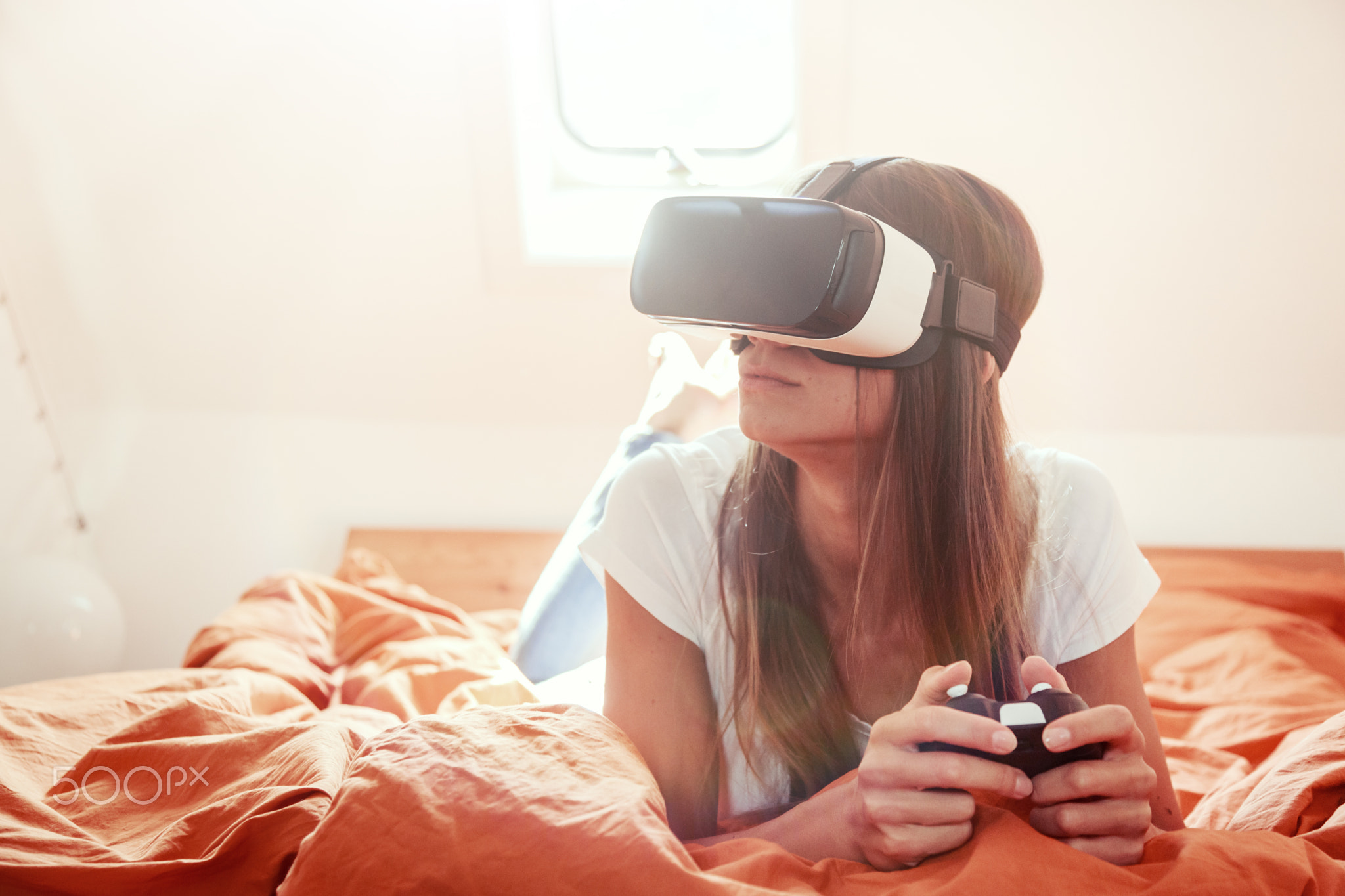 Young Woman Lying On Bed, Using Vr Glasses