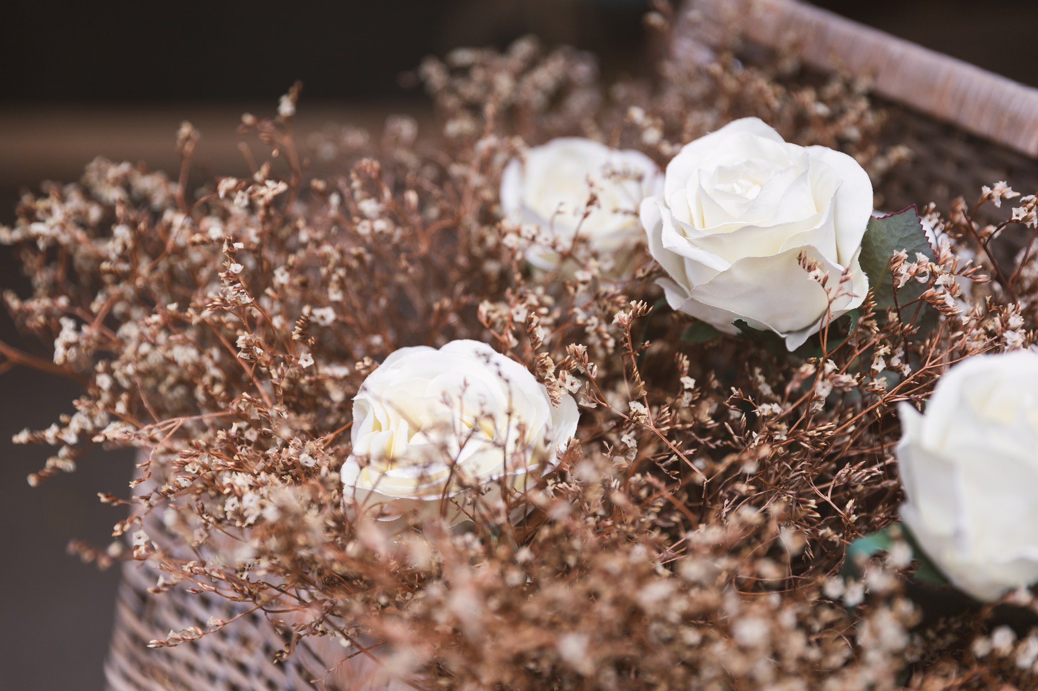 Artificial white rose with dry grass