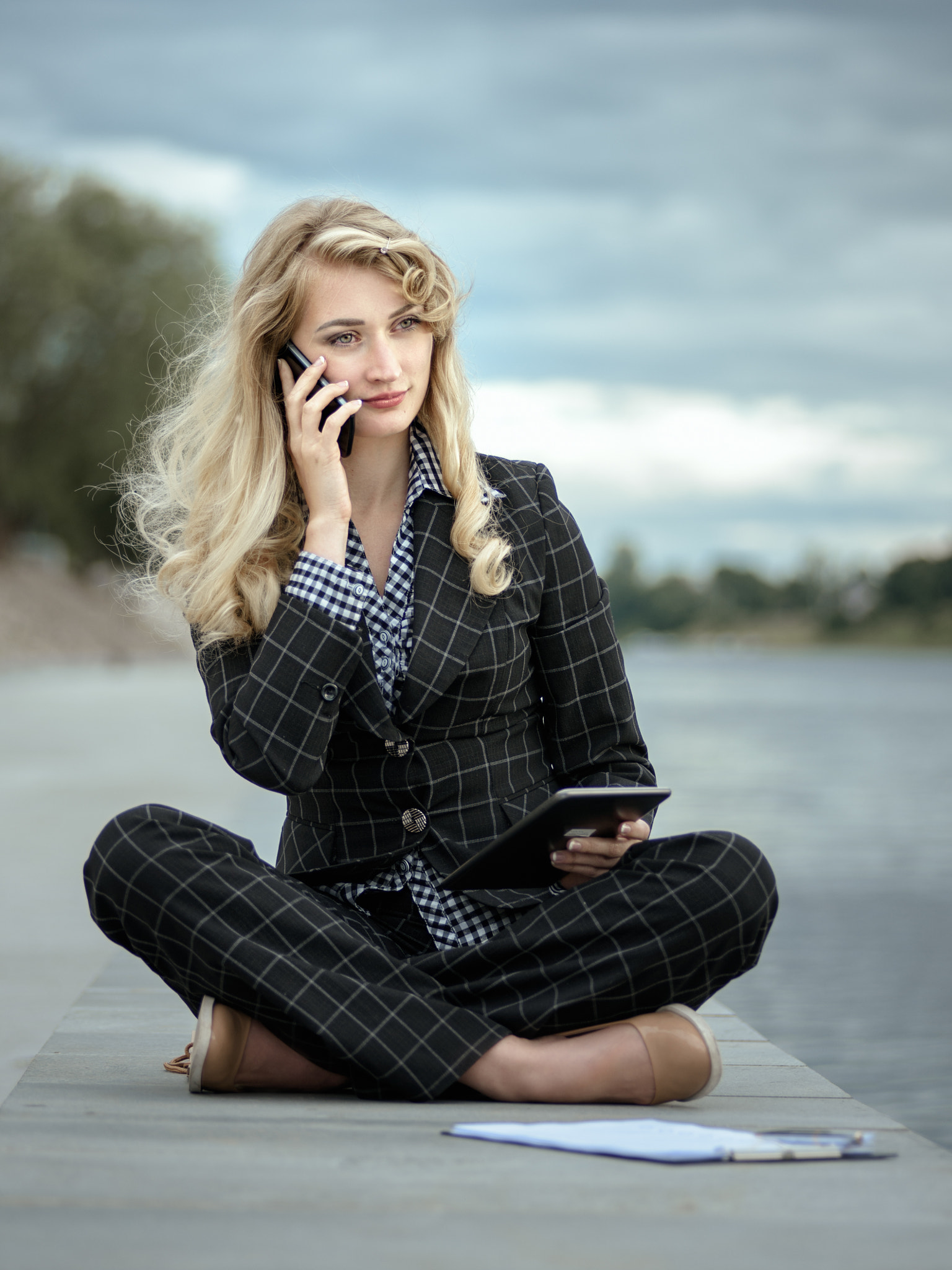 Woman talking phone sitting on pavement