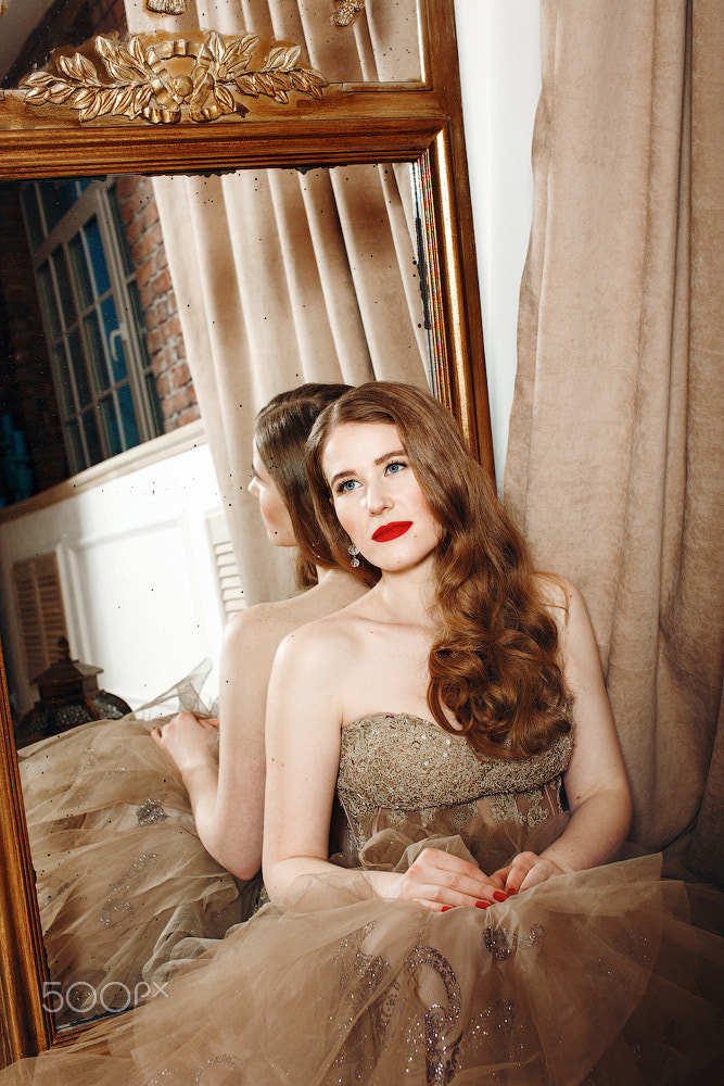 Beautiful pensive woman with red lips in cocktail evening dress