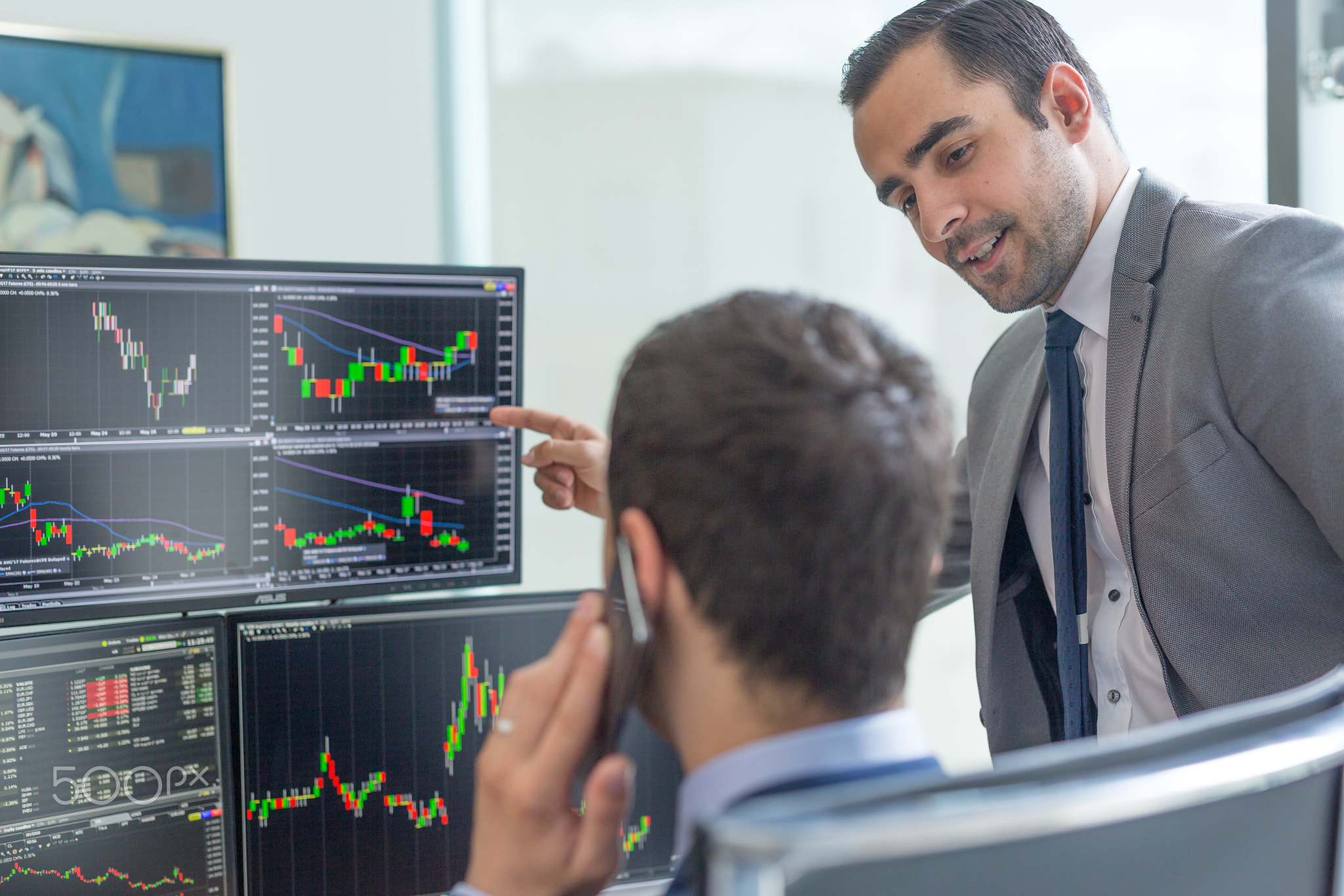 Stock brokers looking at computer screens, trading online.