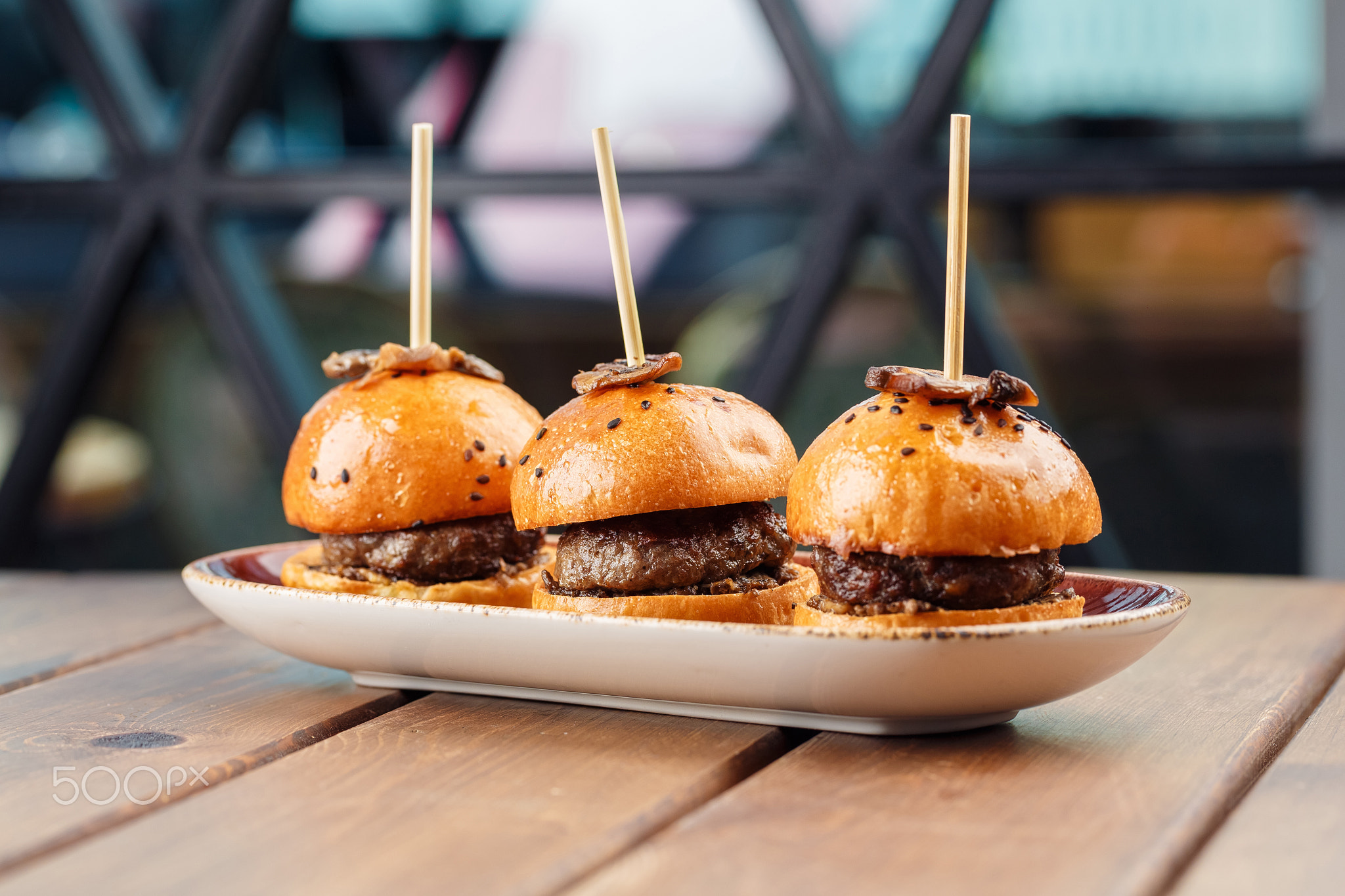 Small burgers served on one plate as appetizers