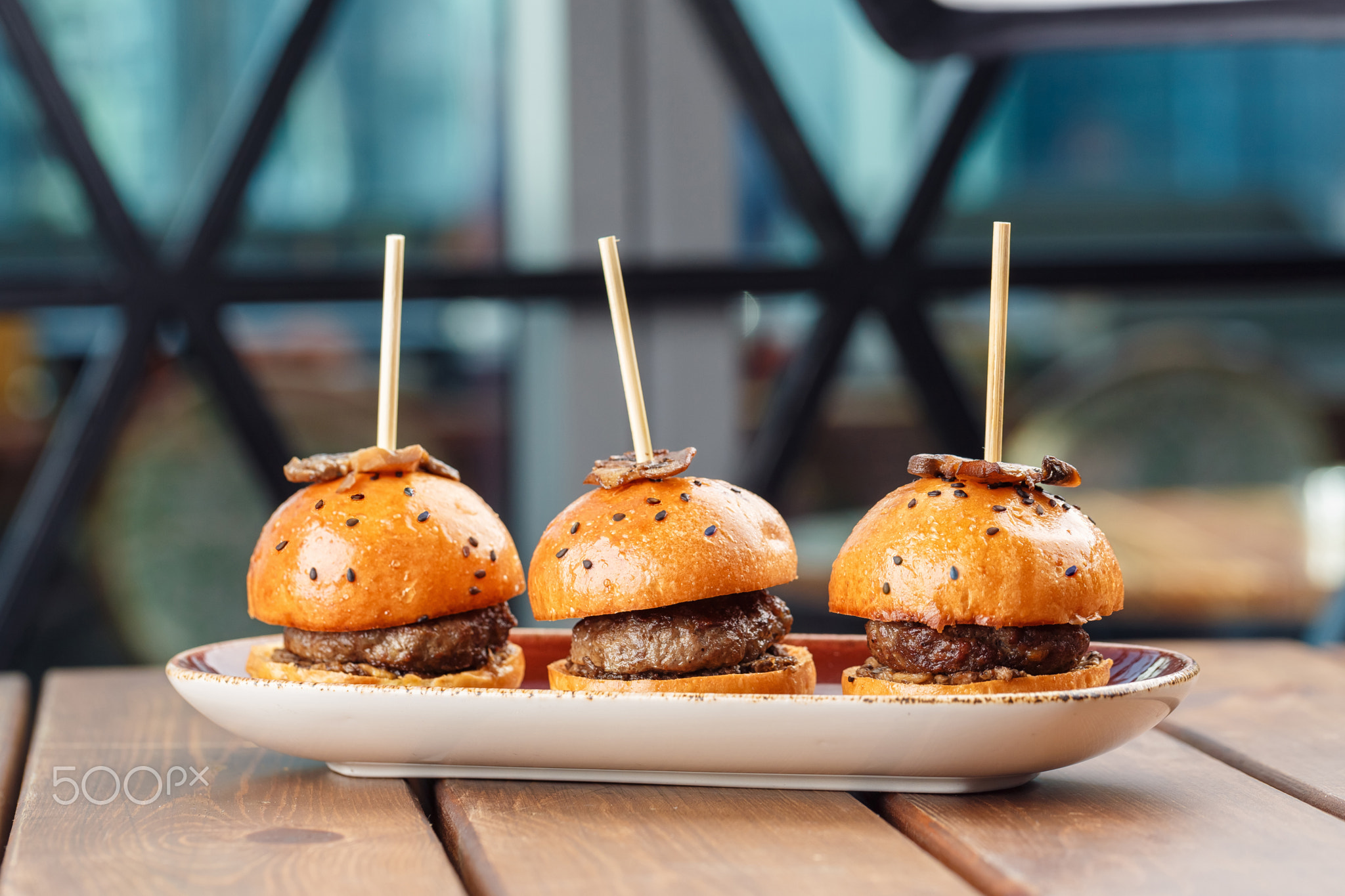 Small burgers served on one plate as appetizers