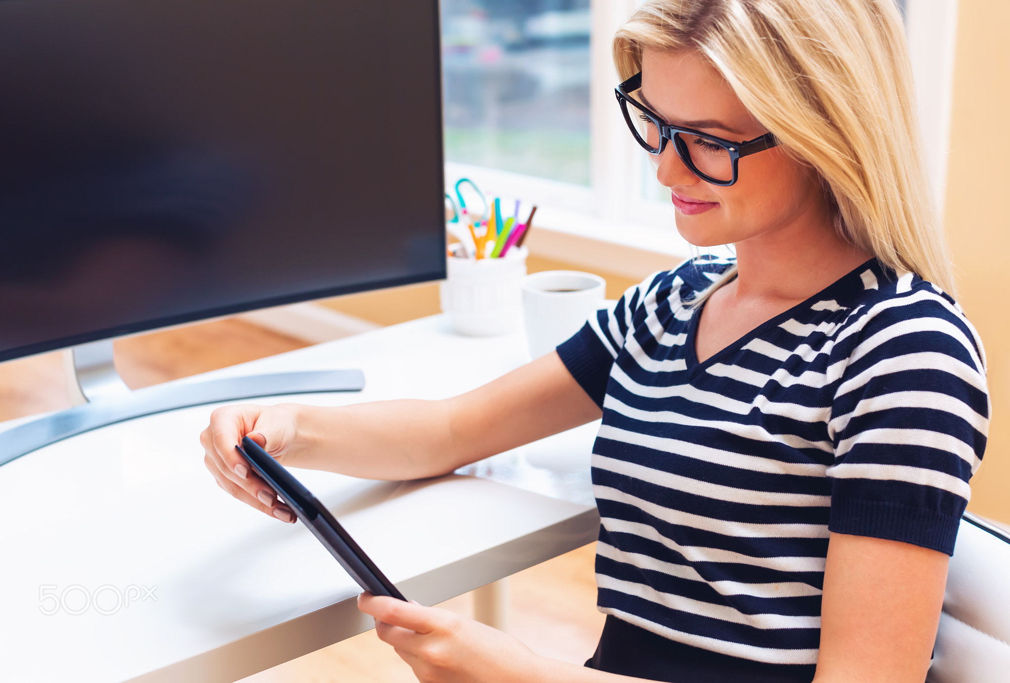 Happy young woman using her tablet