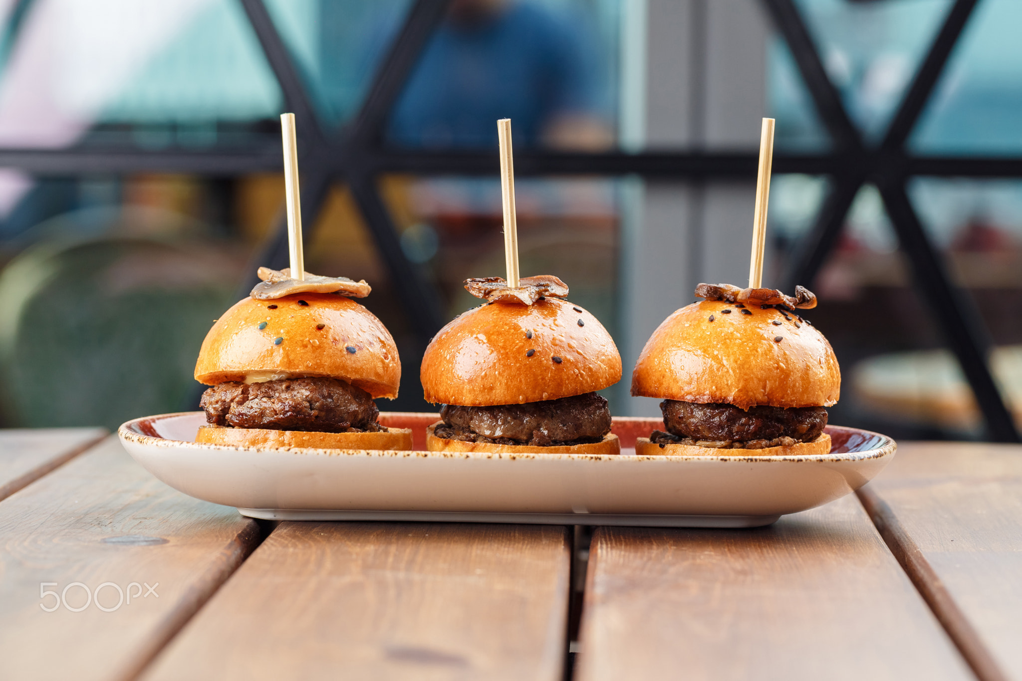 Small burgers served on one plate as appetizers