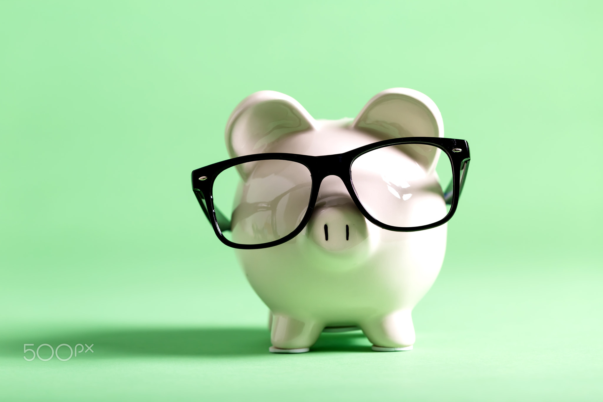 White piggy bank on a green background