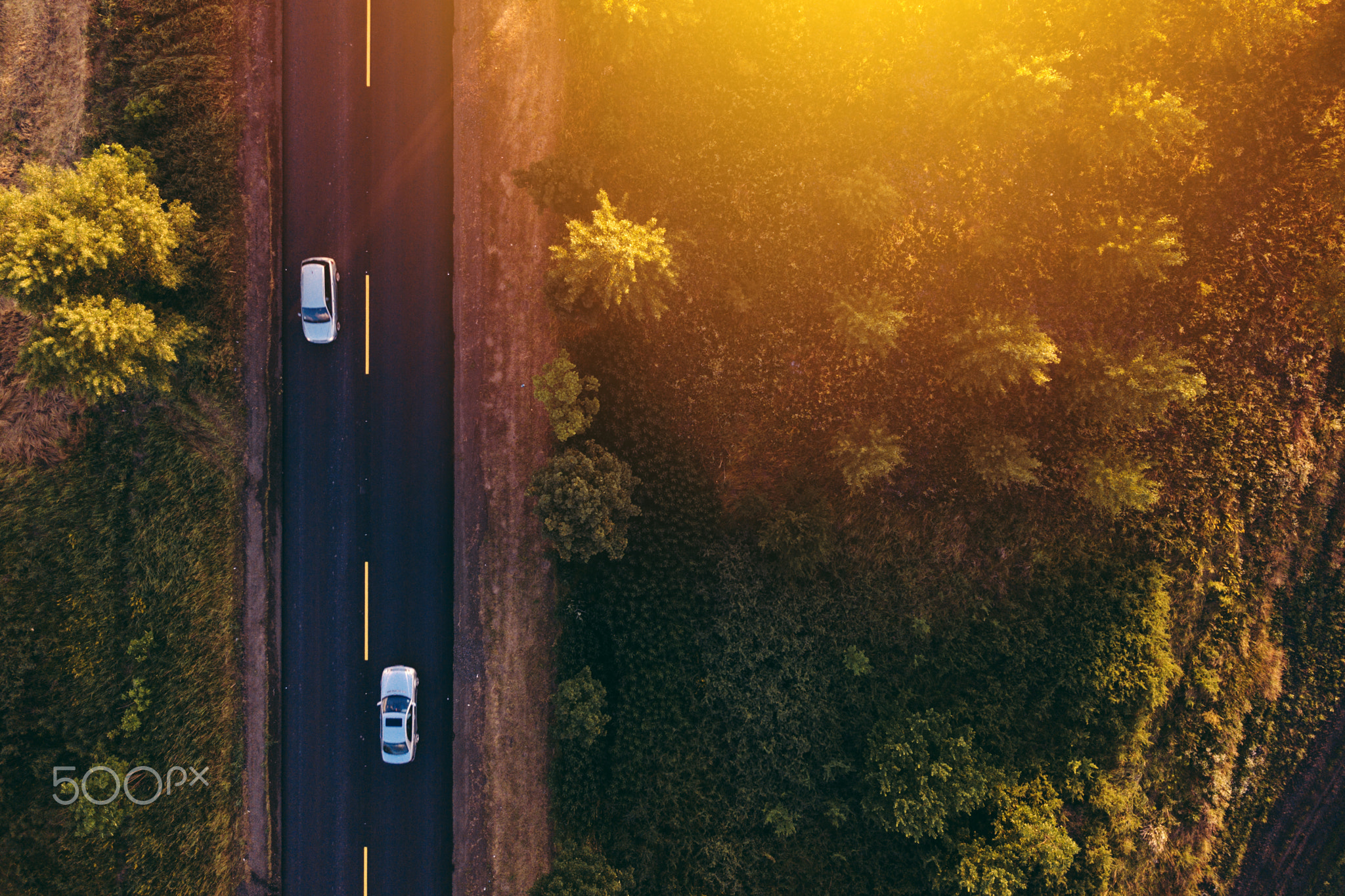 Aerial view of cars on the road in sunset