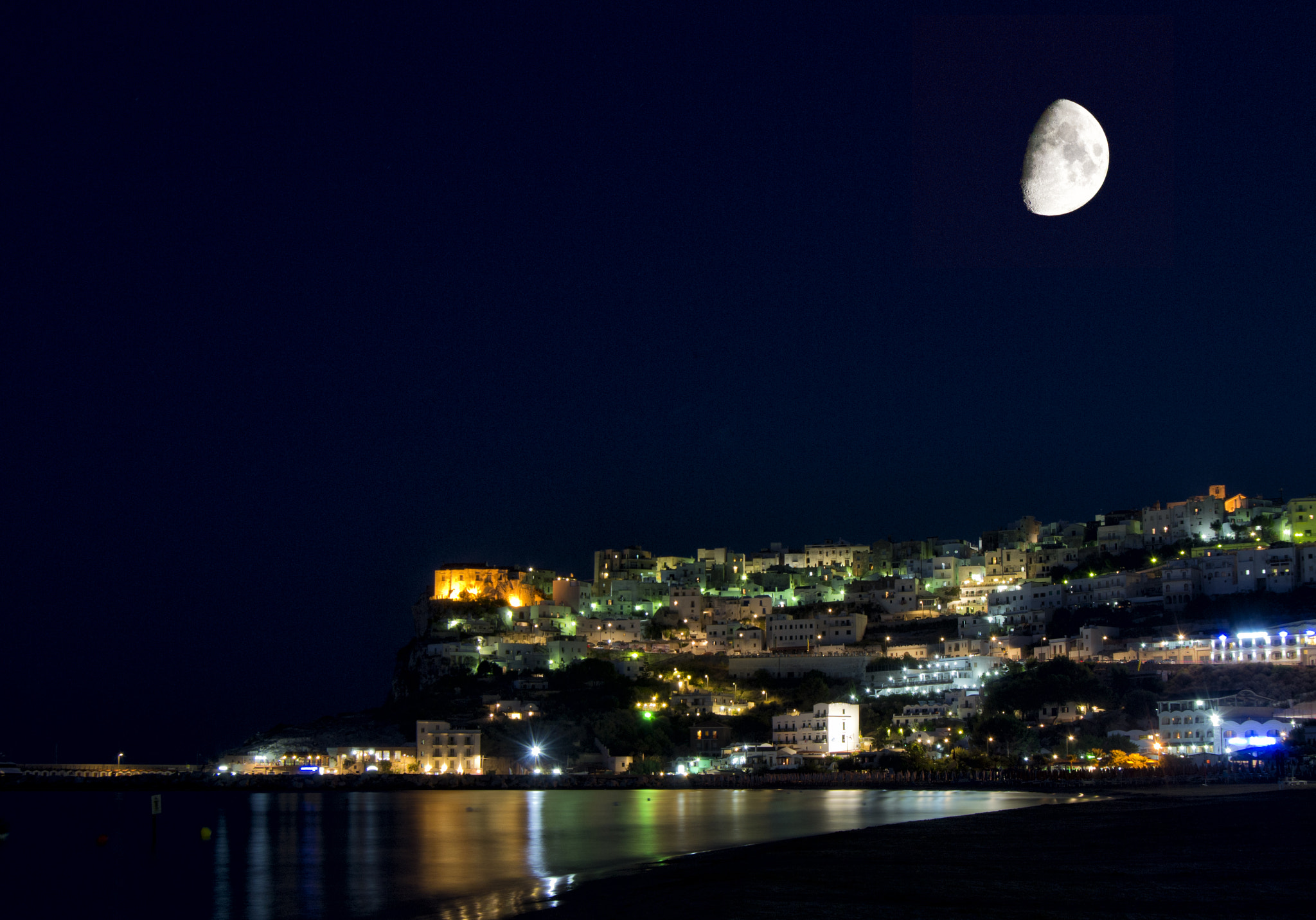 Peschici, Gargano, Apulia, Italy: night with moon, lights and reflections