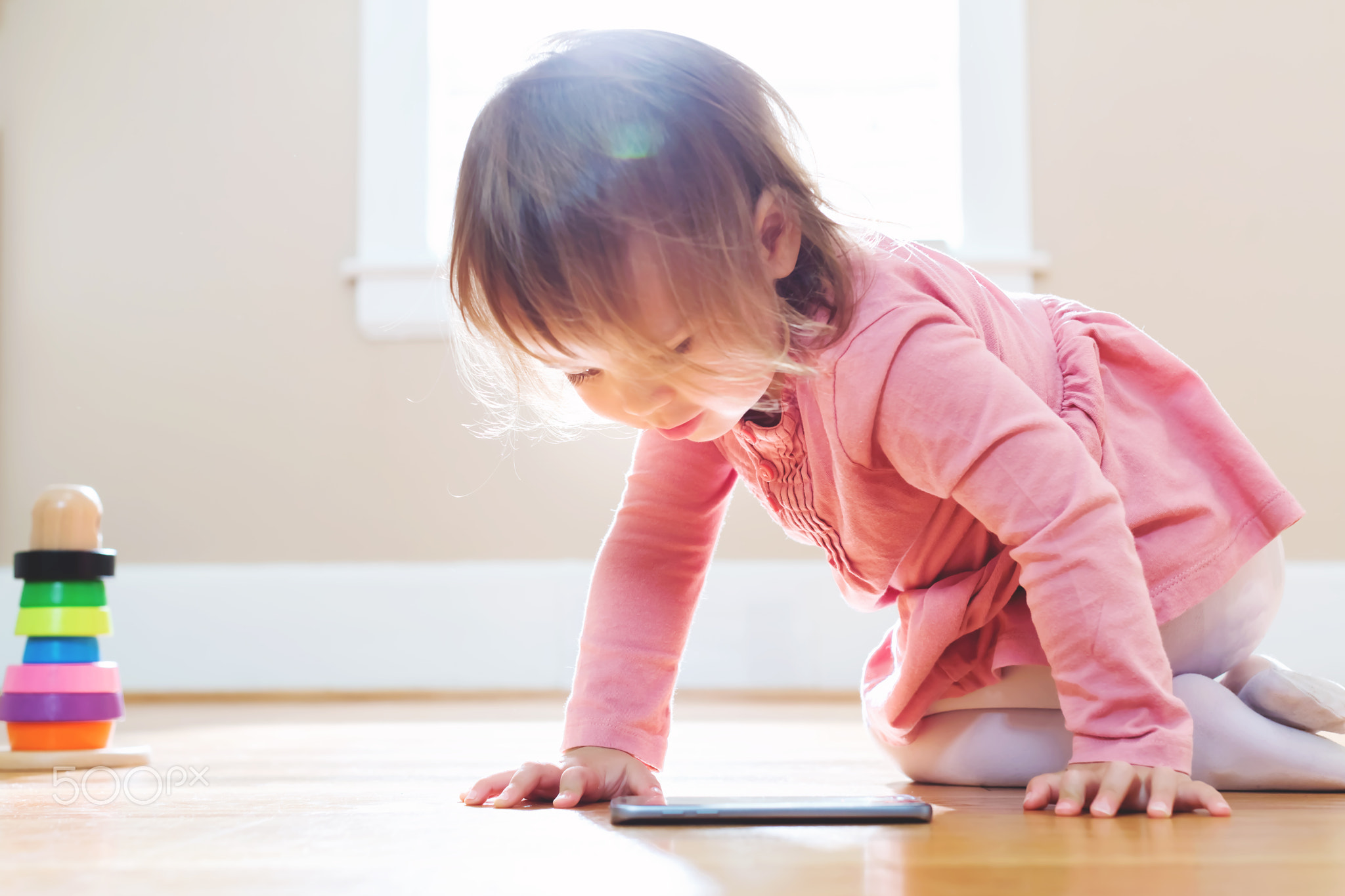 Happy toddler girl playing with her tablet computer