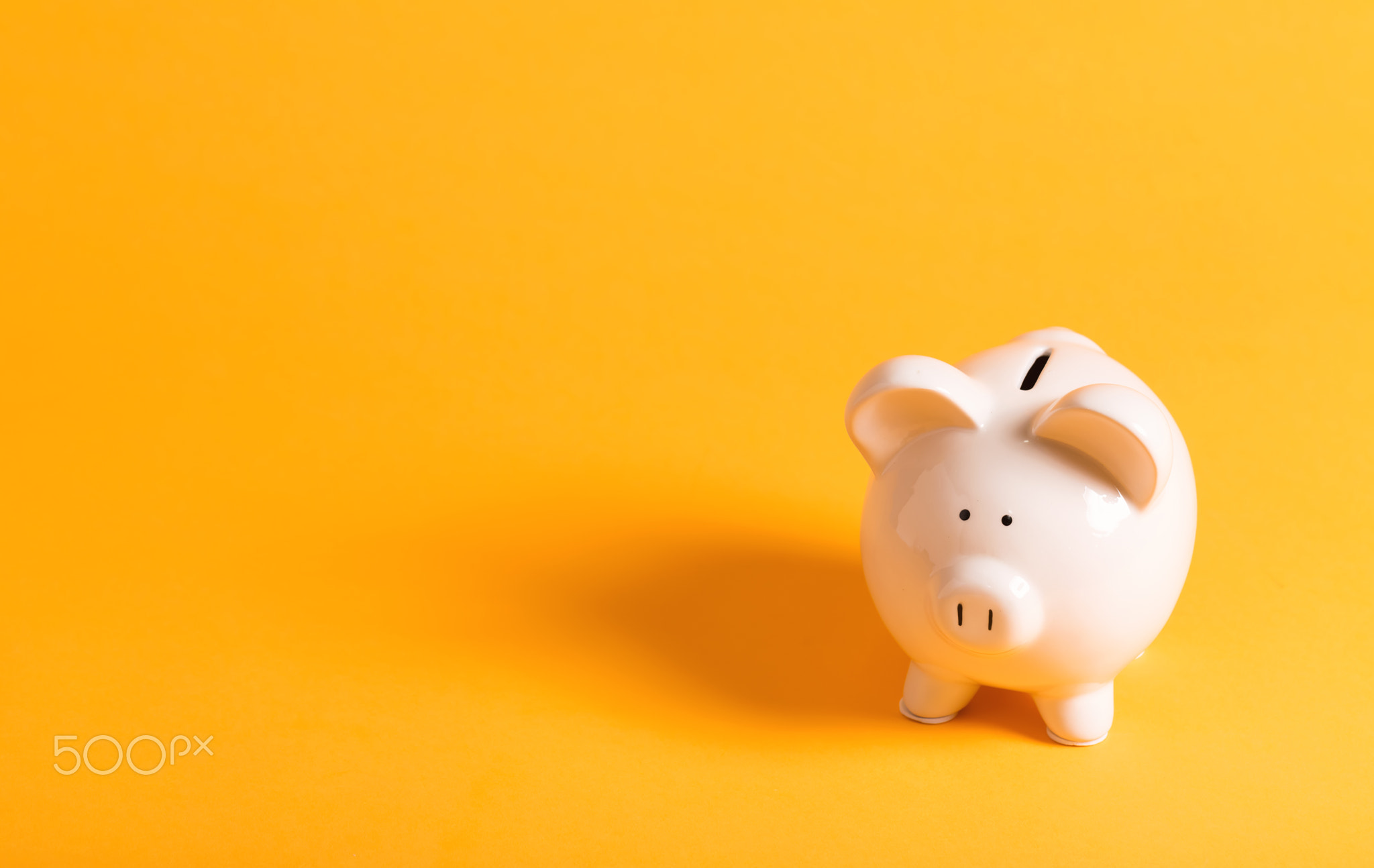 White piggy bank on yellow