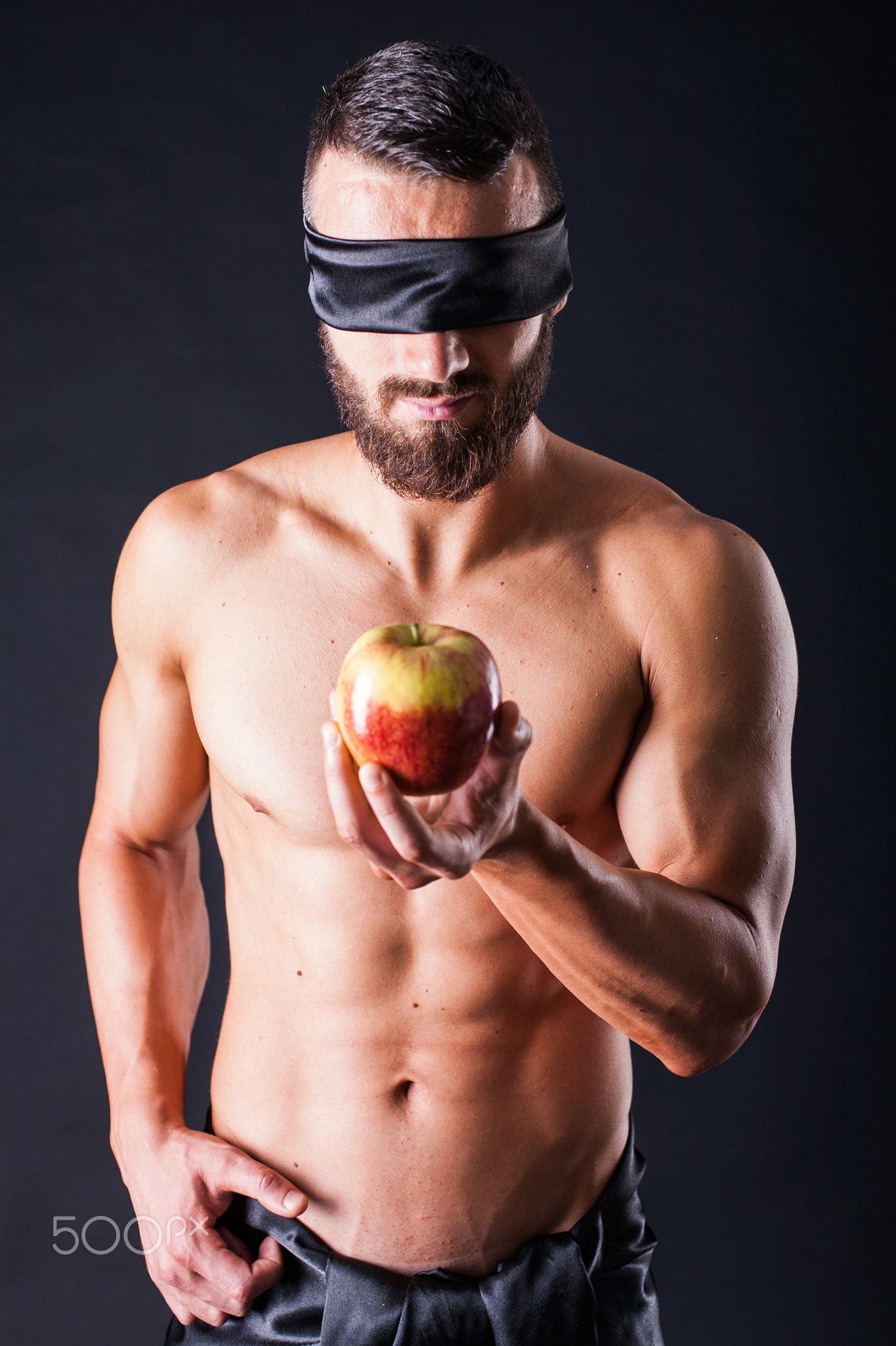 Apple from man with blindfolded eyes