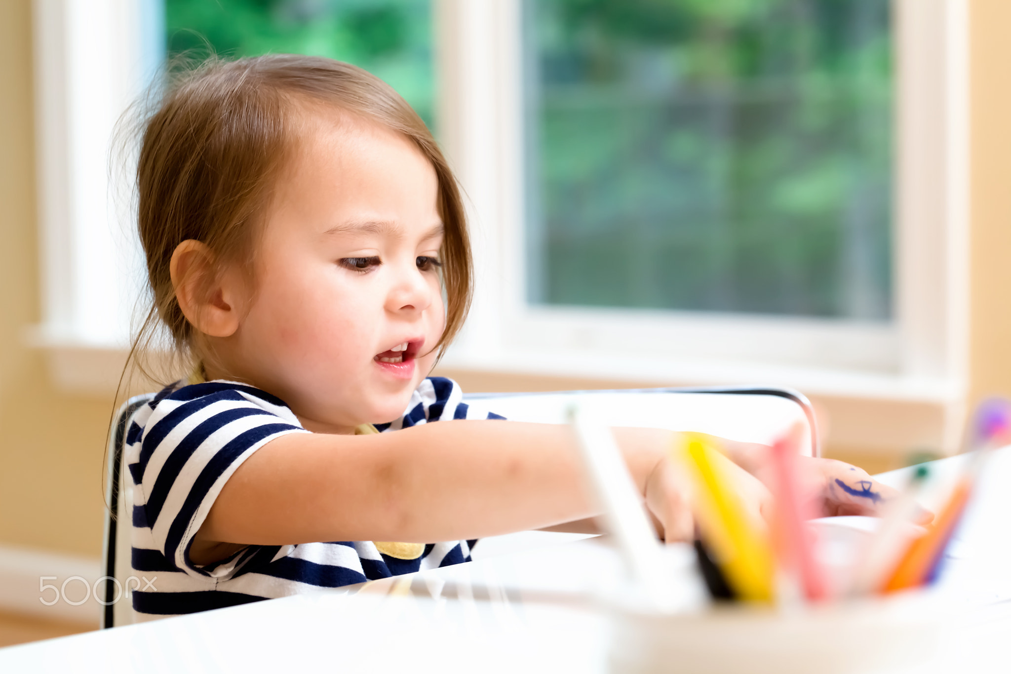 Toddler girl drawing and doing crafts