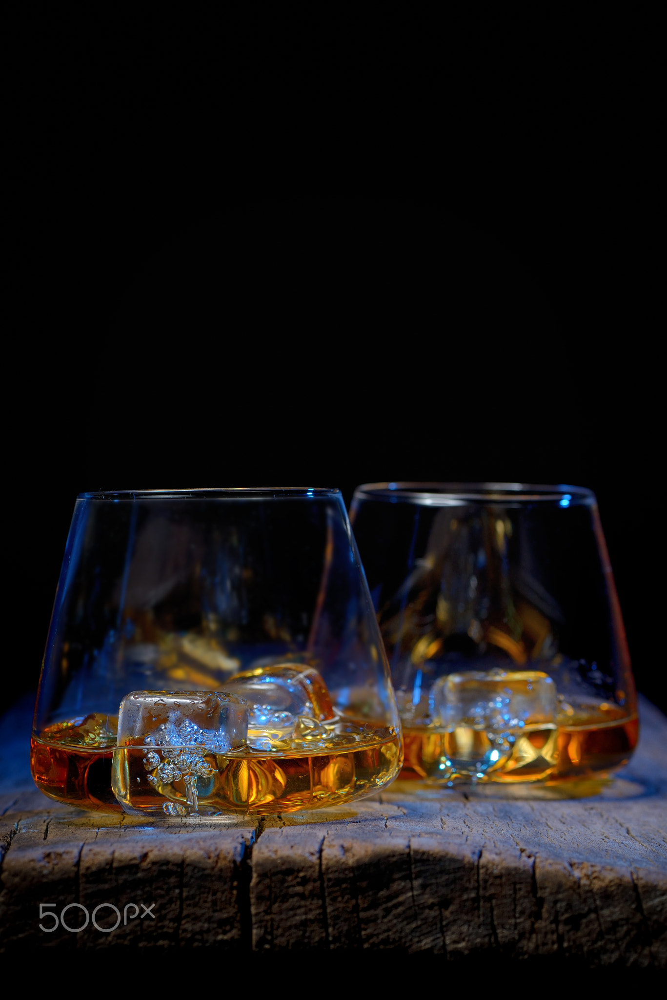 Glass of scotch whiskey and ice isolated