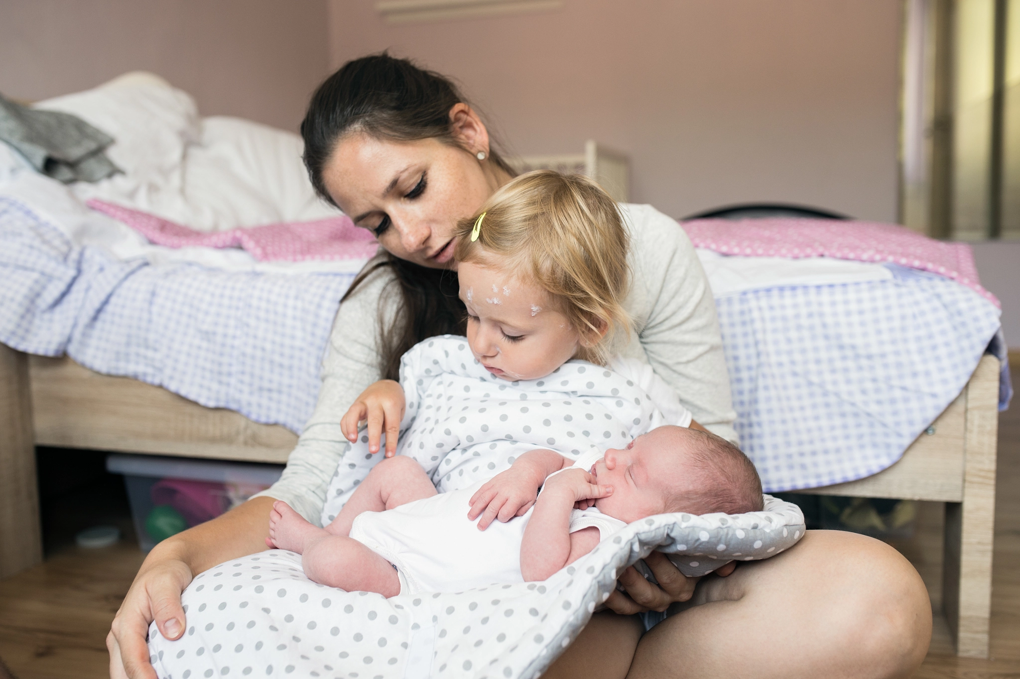 Mother holding daughter with chickenpox and her baby son