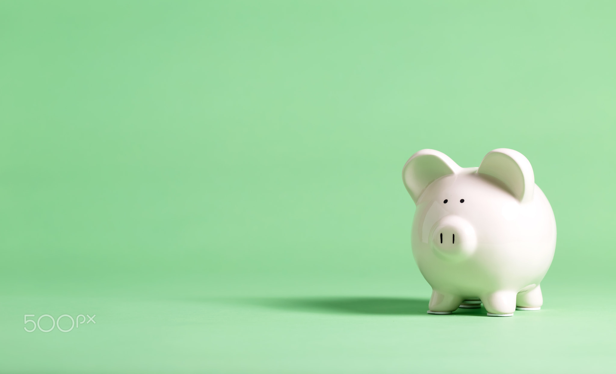 White piggy bank on a green background