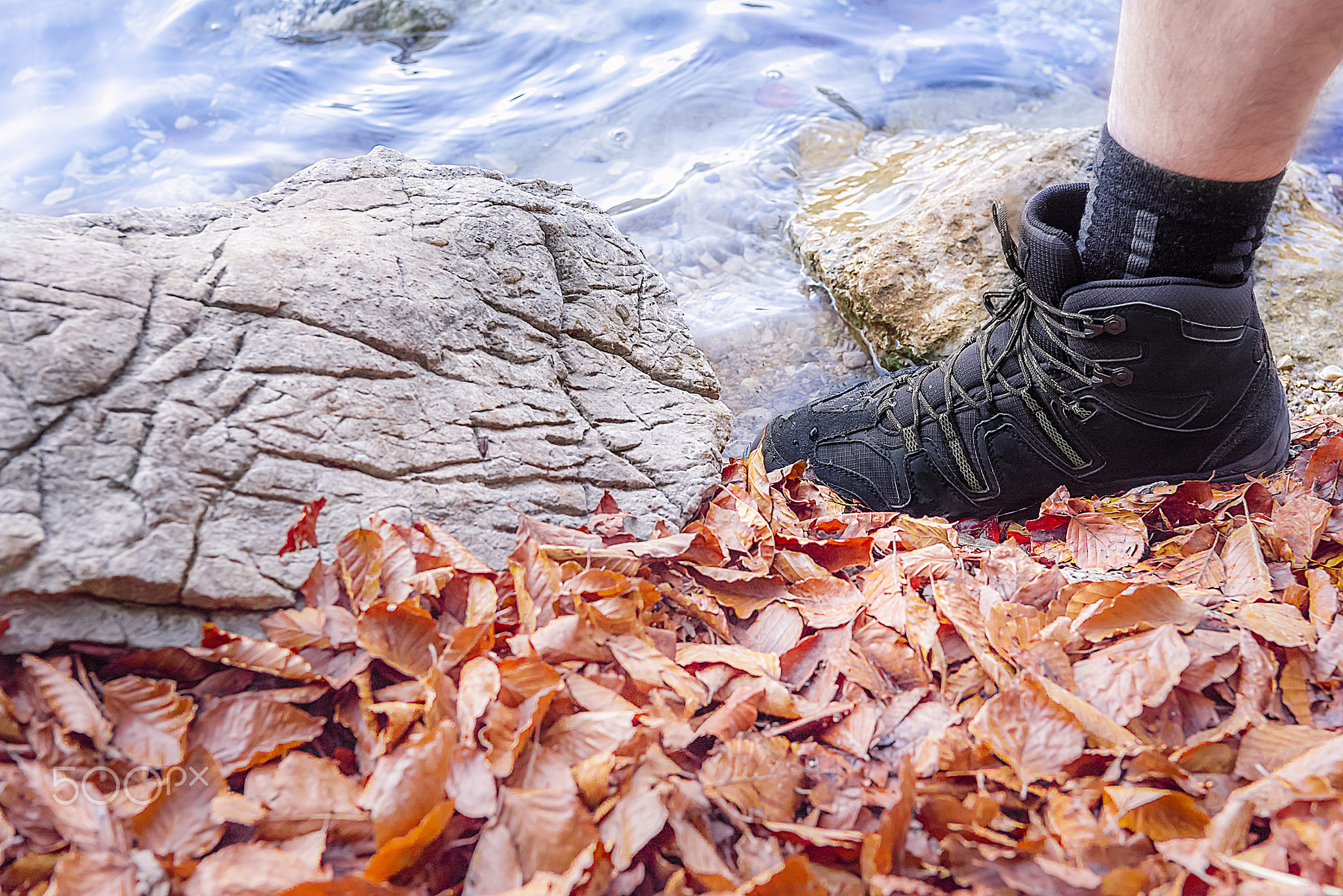 Man foot stepping on rocks and water