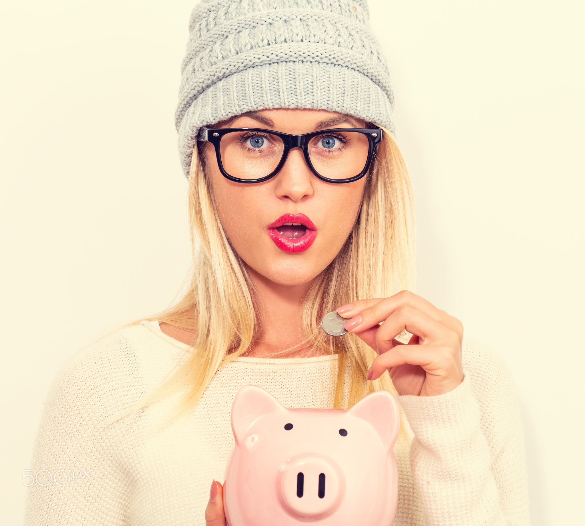 Young woman with a piggy bank