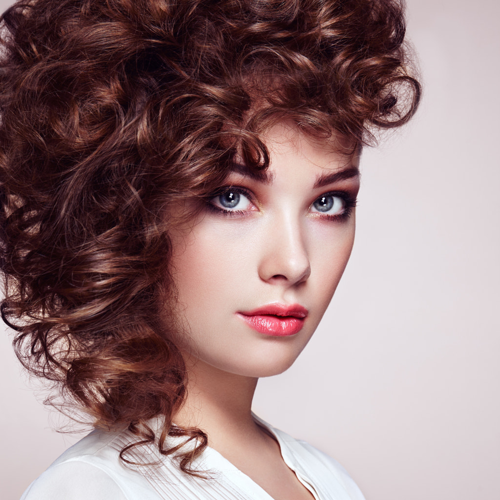 Brunette woman with curly and shiny hair by Oleg Gekman / 500px