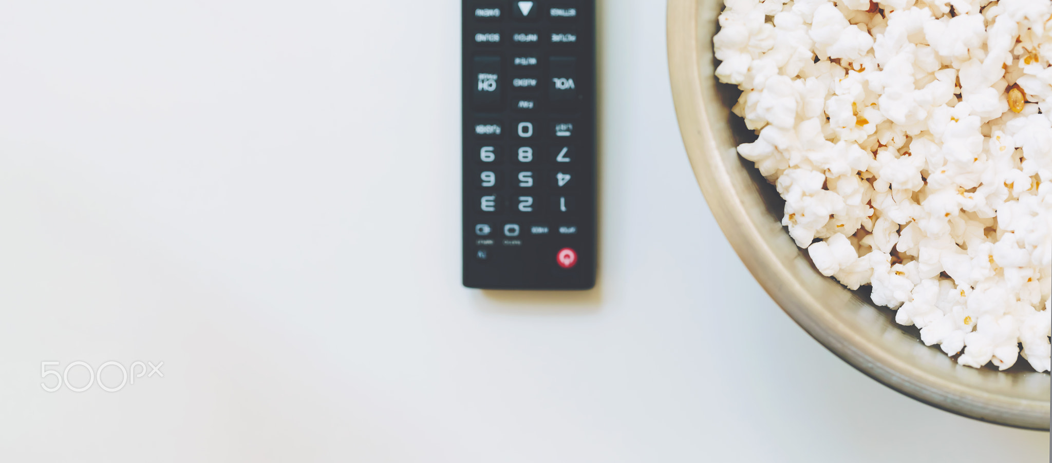 TV remote control with bowl of popcorn