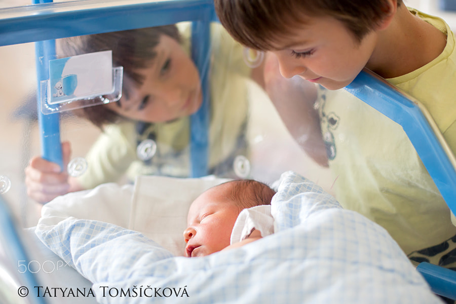 Beautiful newborn baby boy, laying in crib in prenatal hospital,